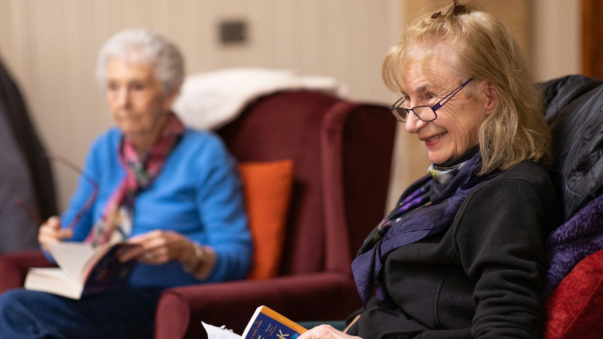 a woman sitting in a chair reading a book