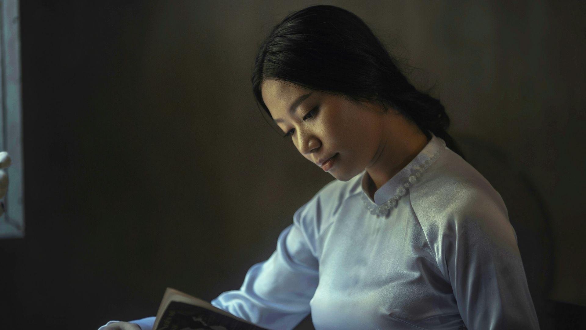 woman wearing gray long-sleeved tops reading book