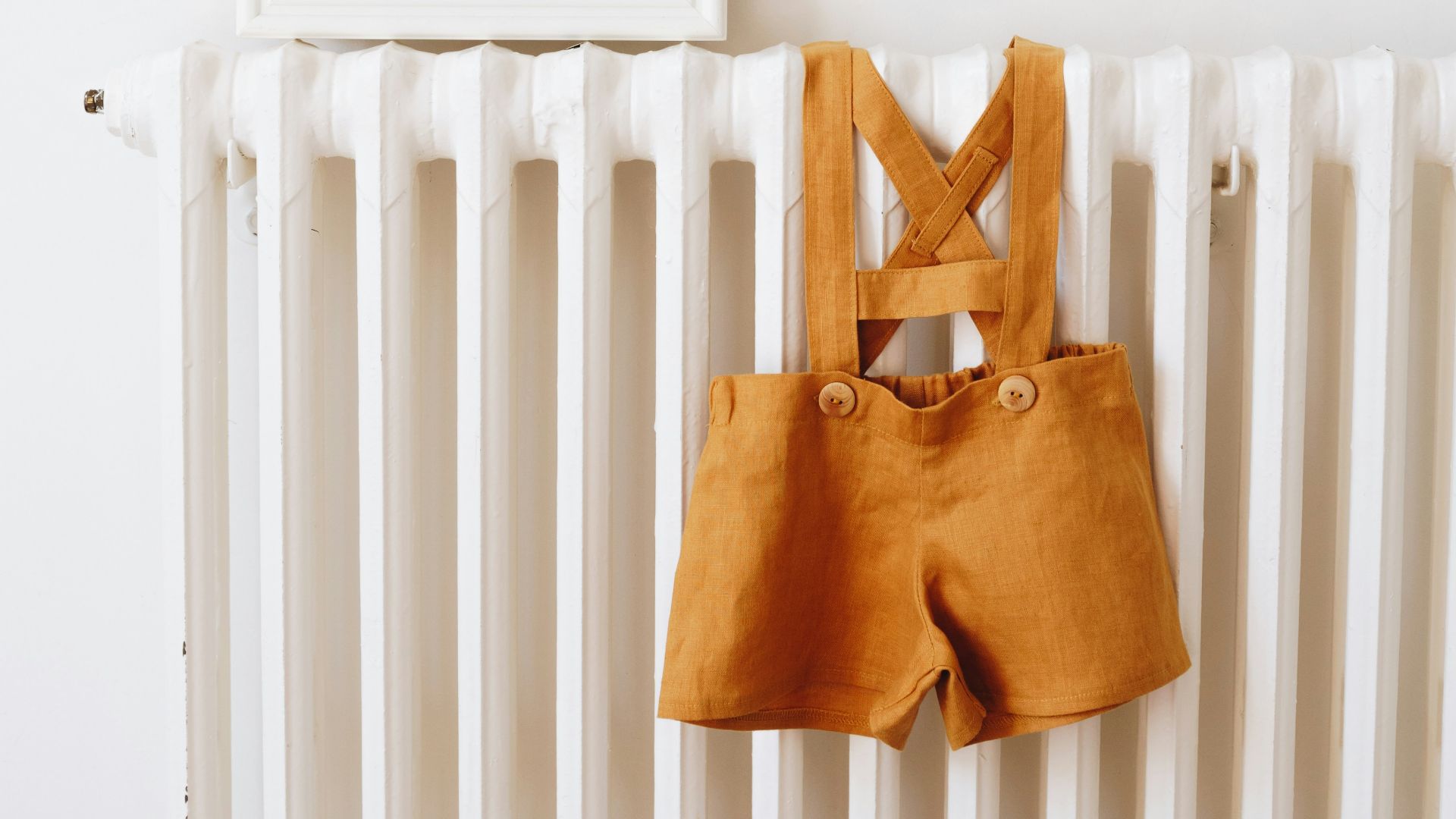 a baby's clothes hanging on a radiator