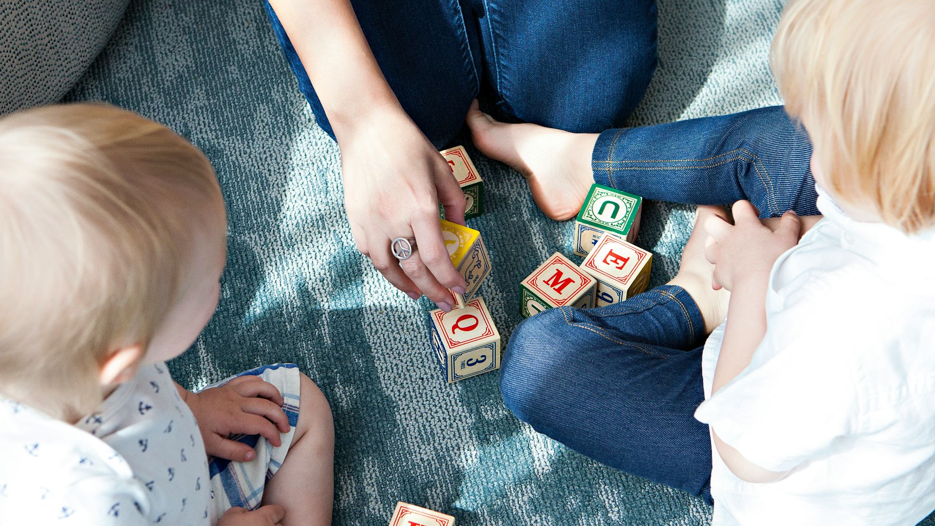 two toddler playing letter cubes