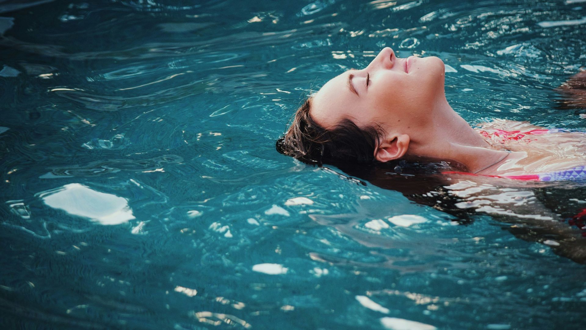 woman floating on body of water