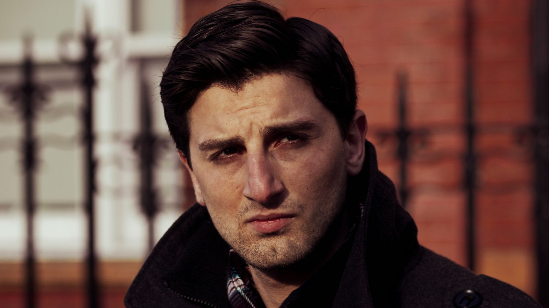 a man standing in front of a fence