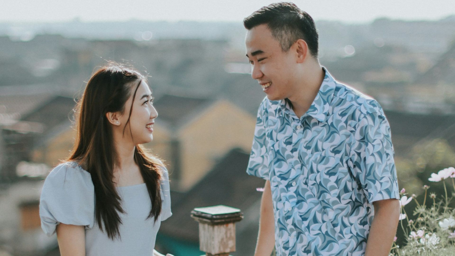 Couple talking on a balcony overlooking town