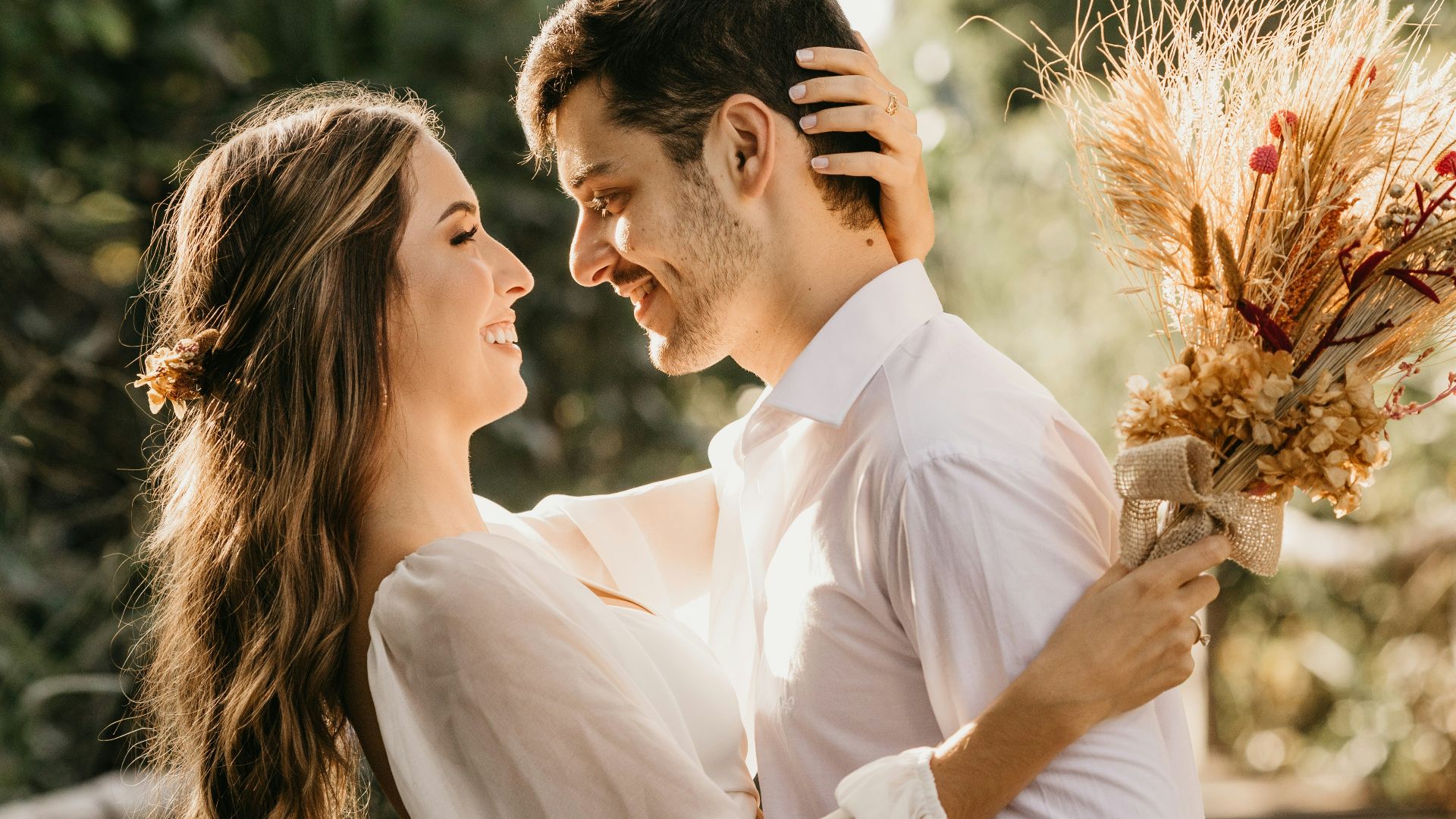 man in white dress shirt holding brown flower bouquet