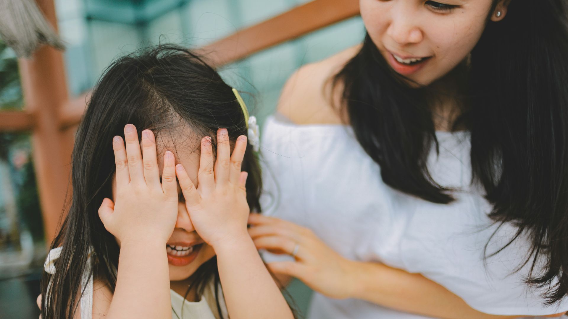A mother and daughter playing peek-a-boo
