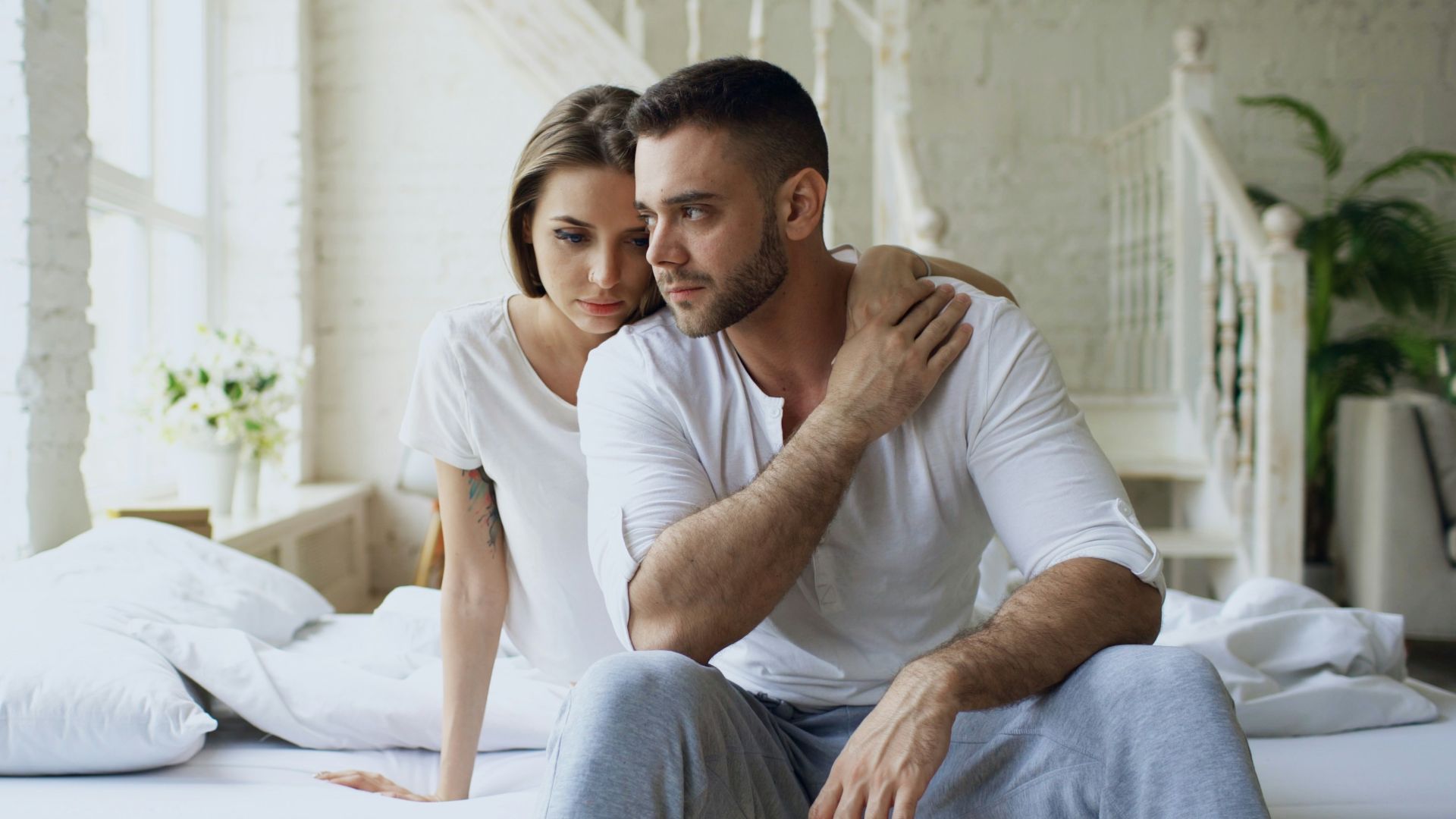 Couple sitting on a bed in a bright room