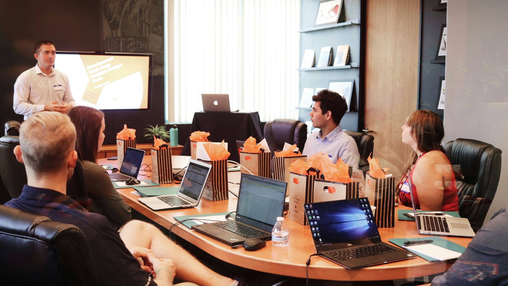 man standing in front of people sitting beside table with laptop computers