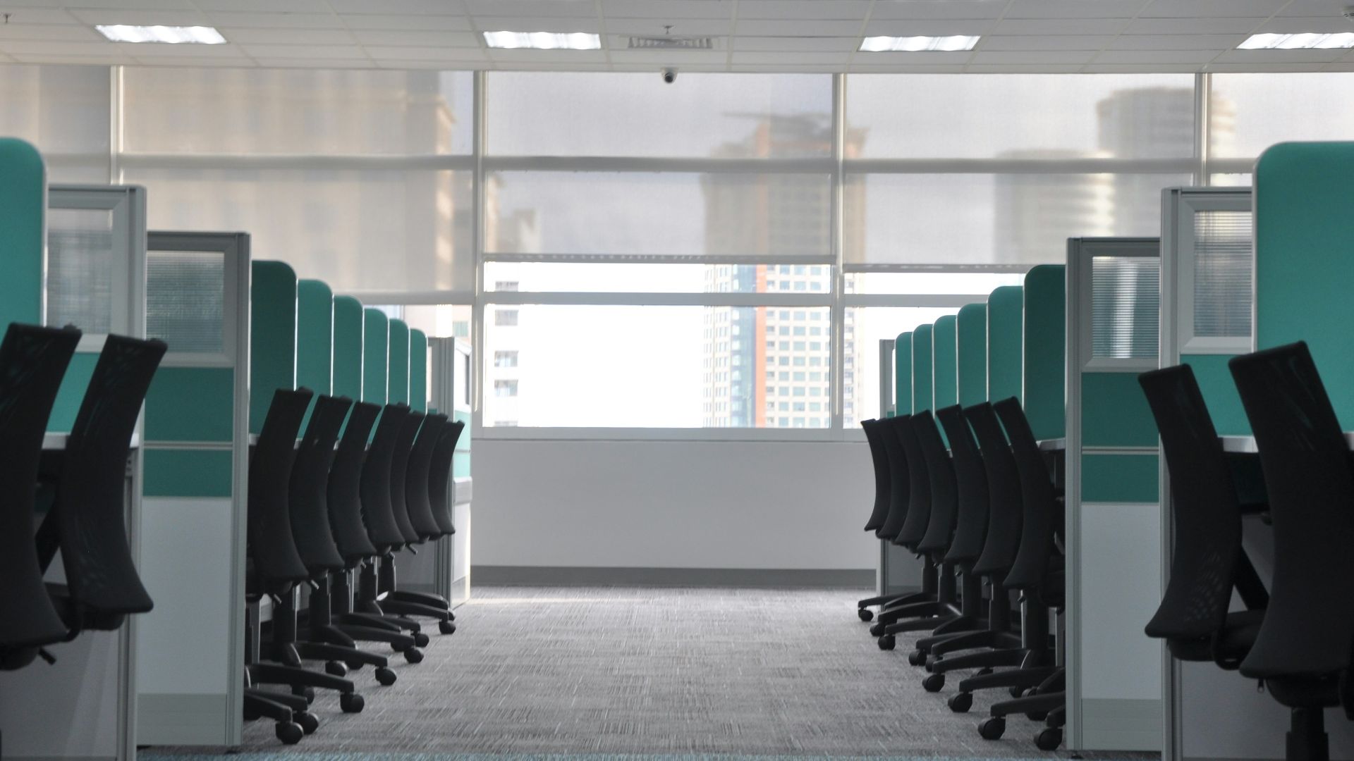 empty black rolling chairs at cubicles