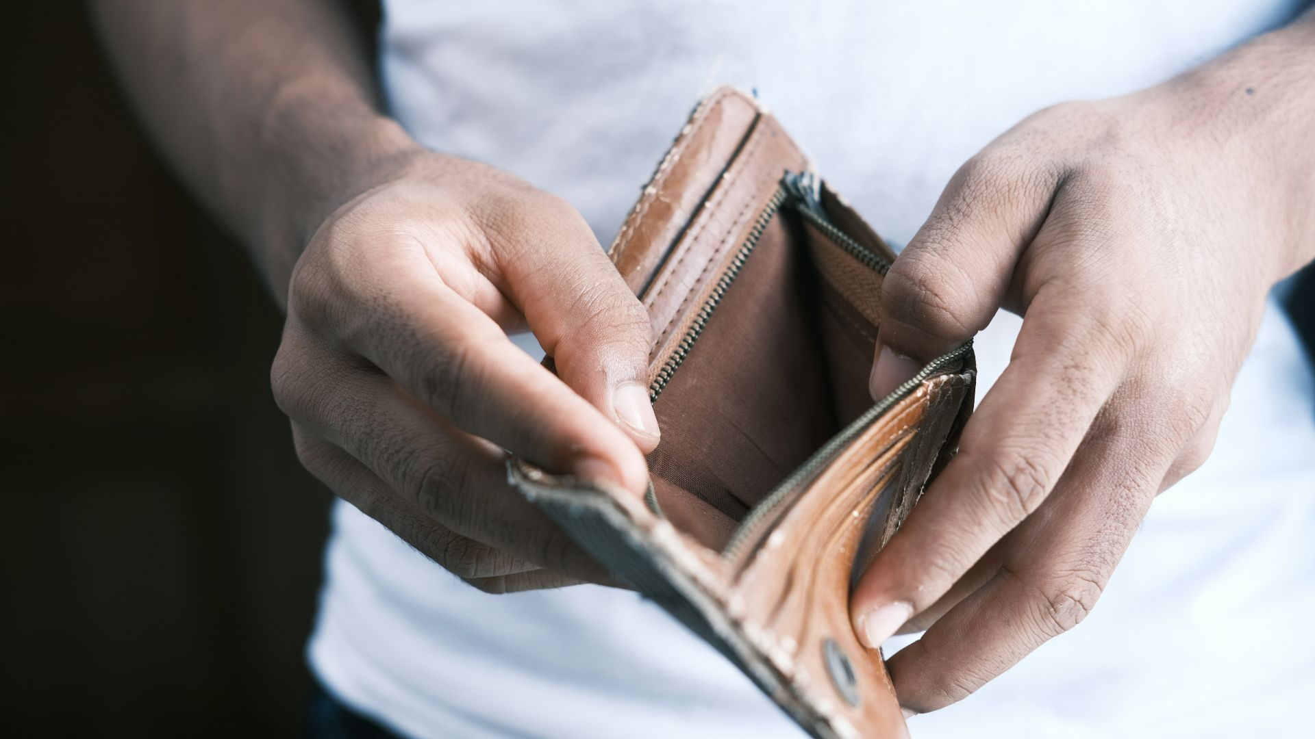 person holding brown leather bifold wallet