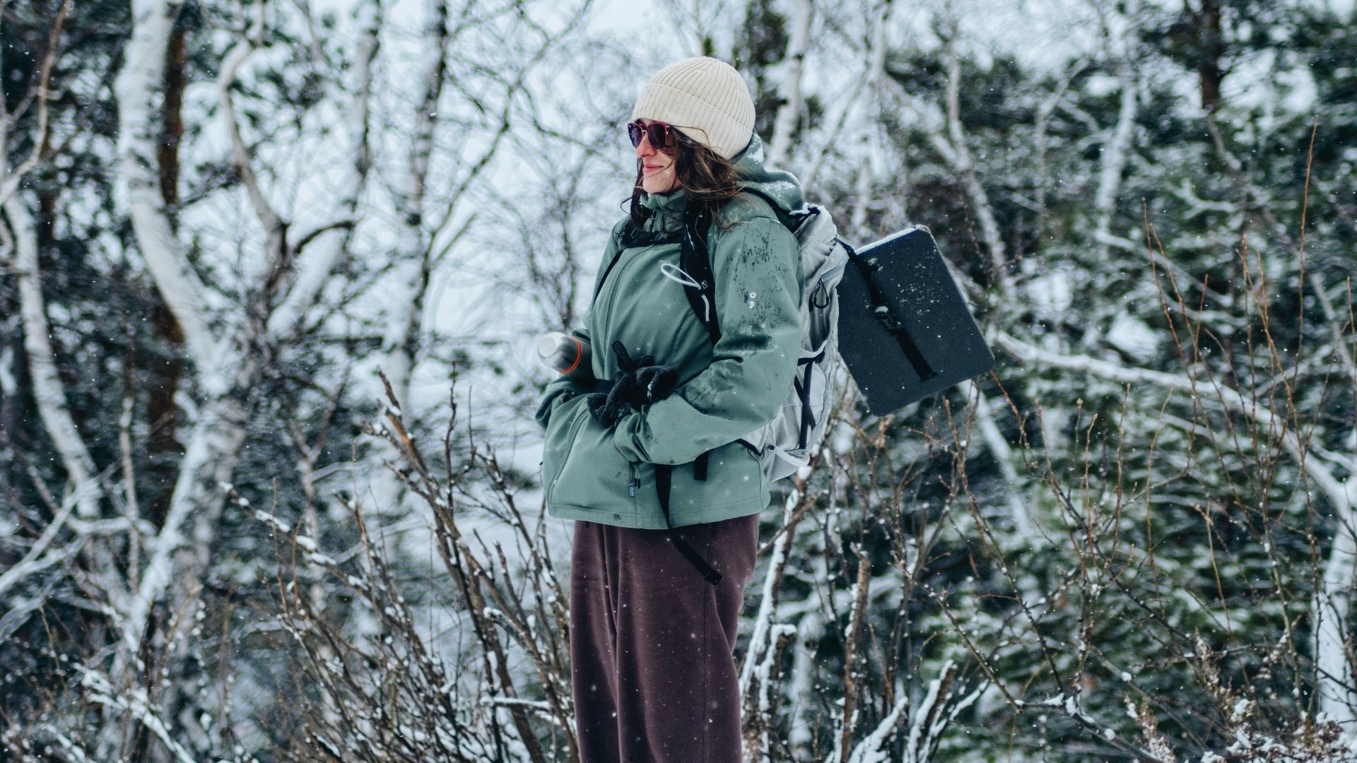 A person standing in the snow with a backpack