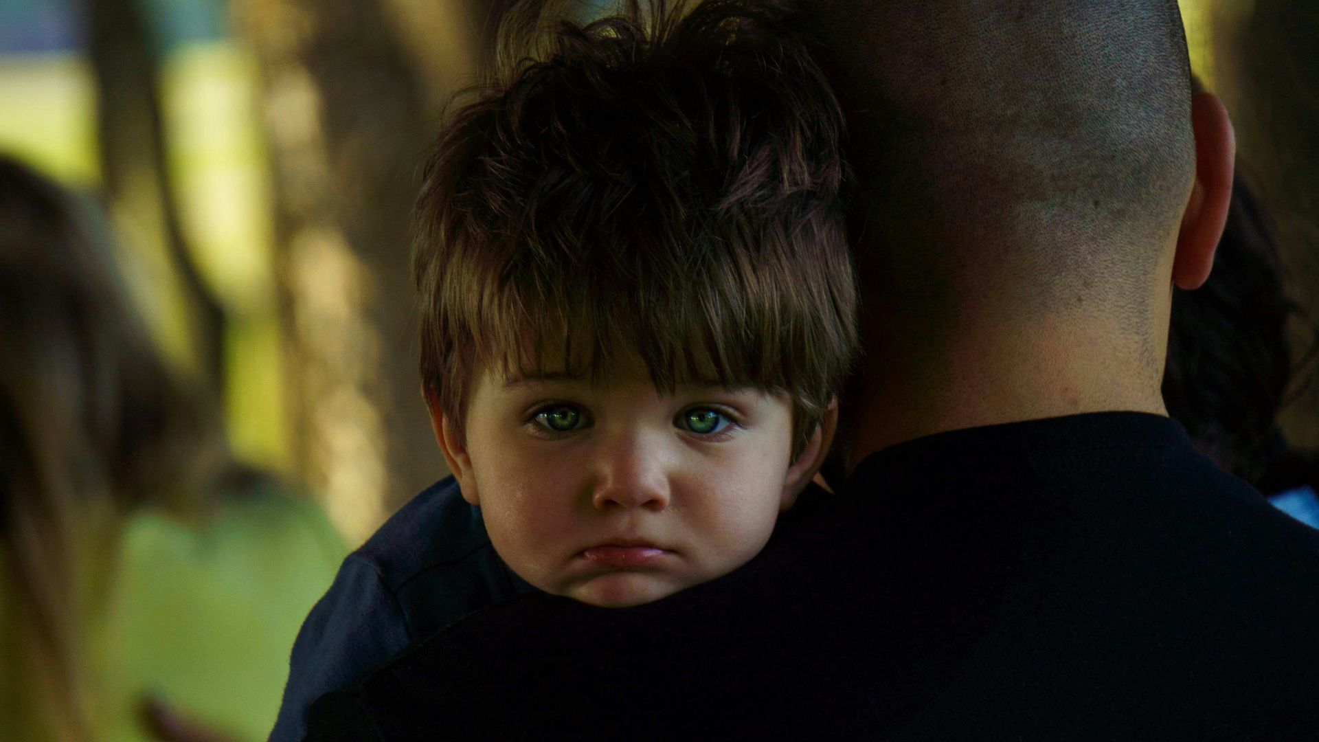 a man holding a little boy in his arms
