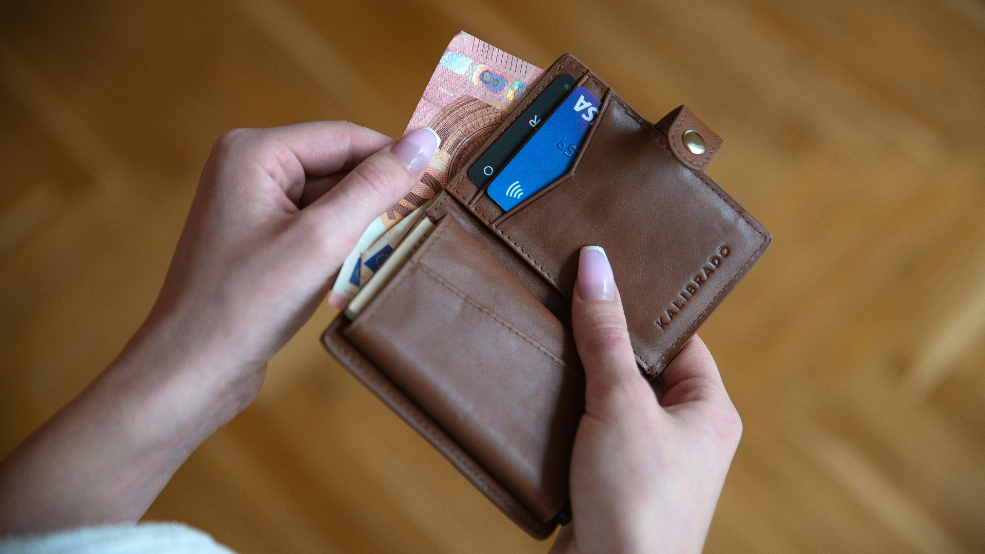 person holding brown leather card wallet