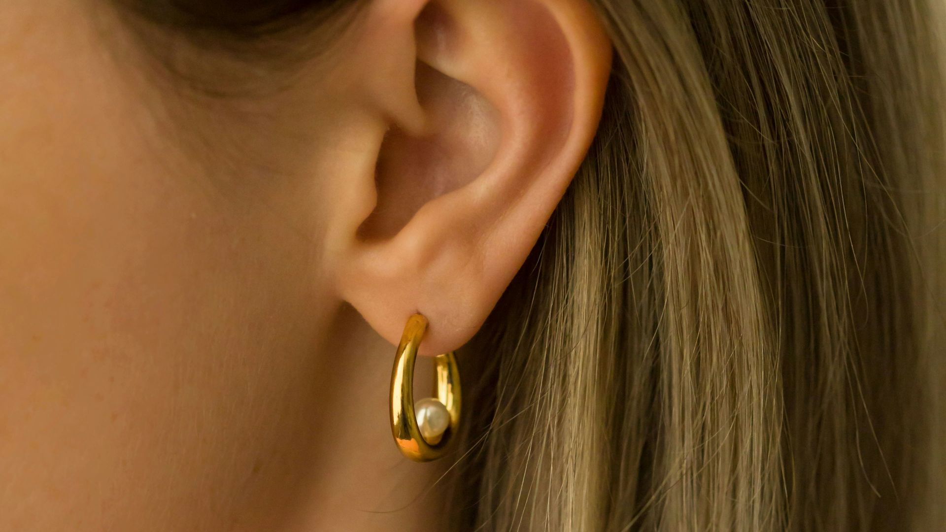 a close up of a person wearing a pair of earrings