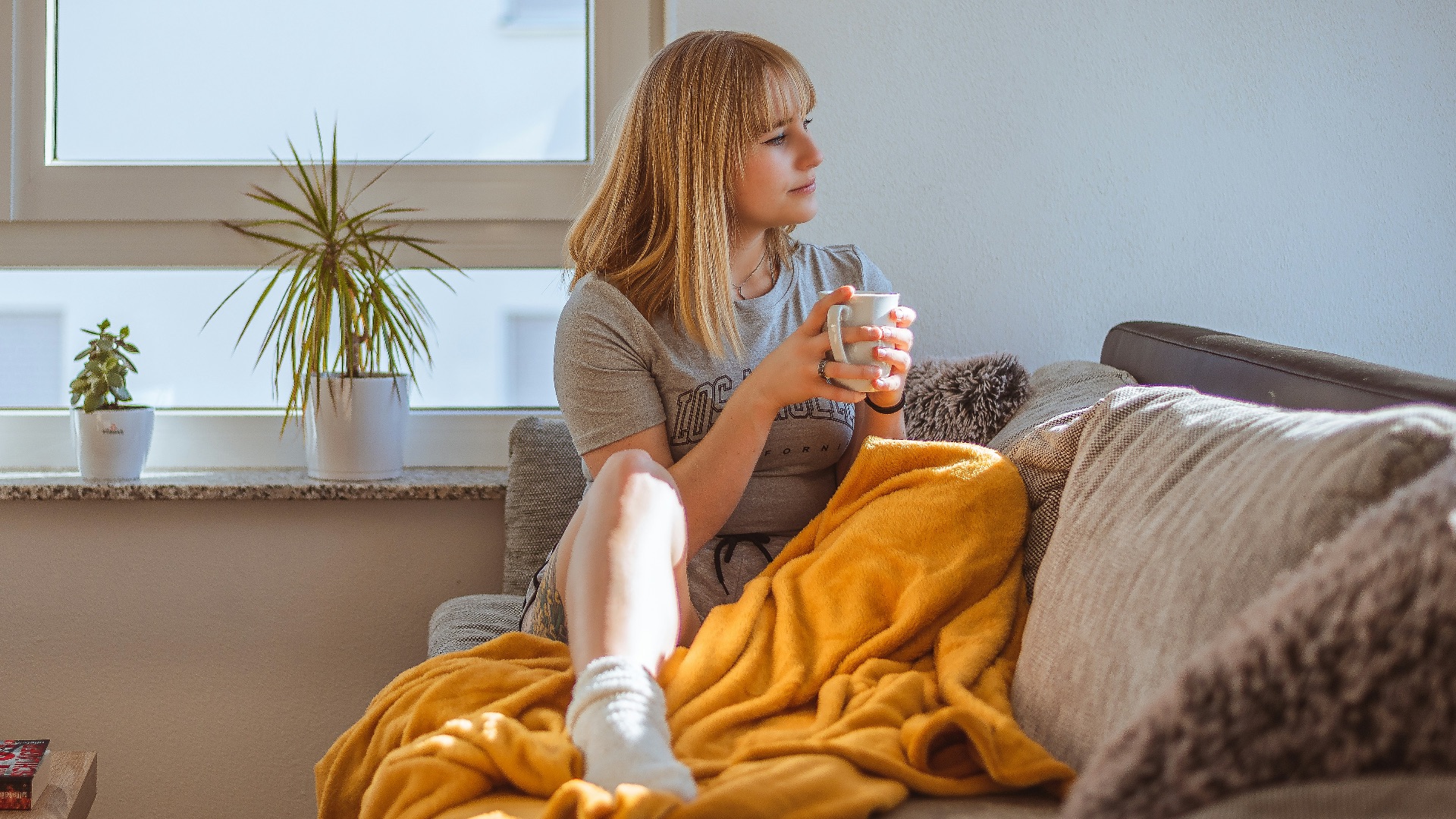 a woman sitting on a couch holding a glass of water