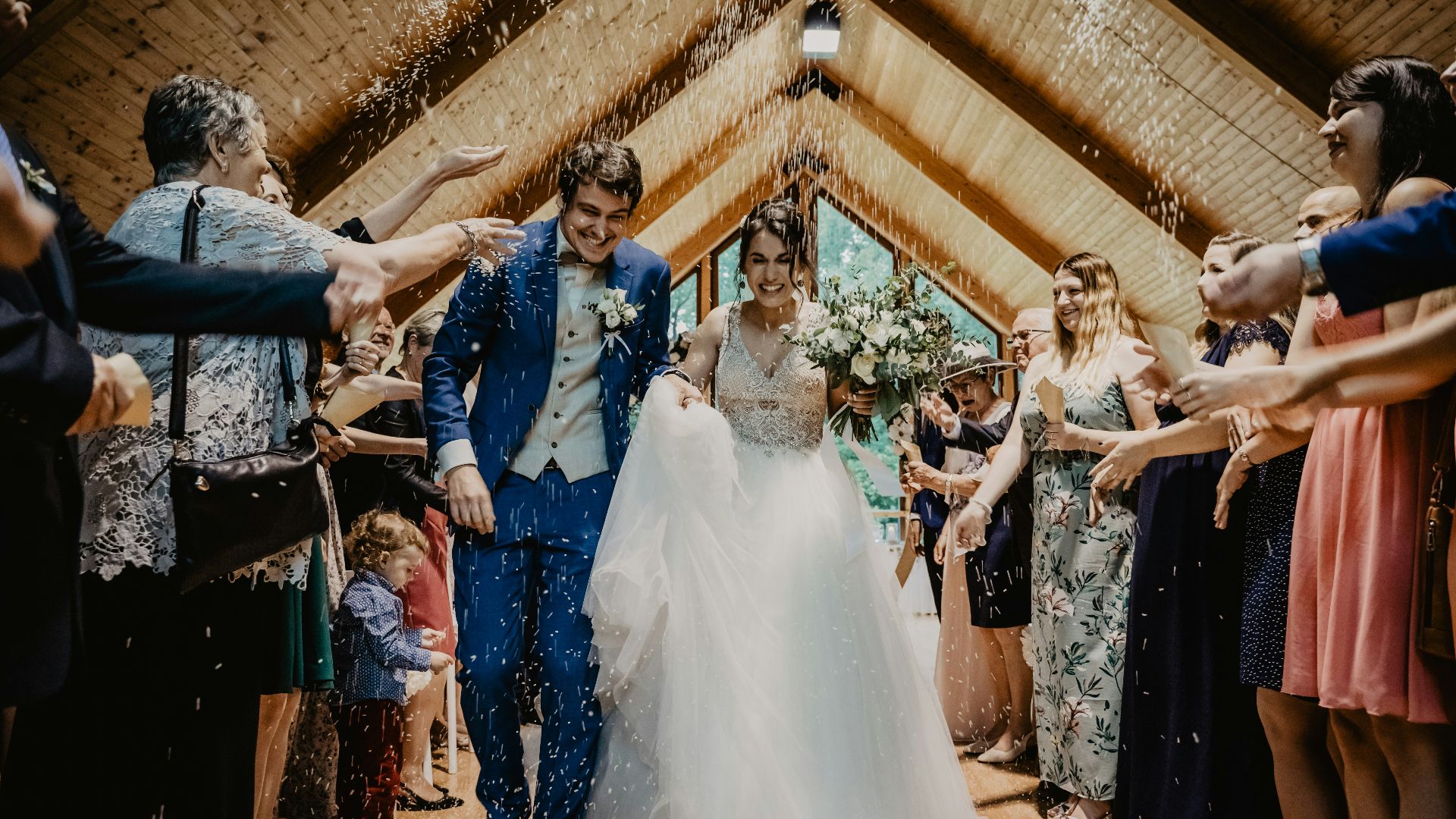 bride and groom standing beside brown wooden wall