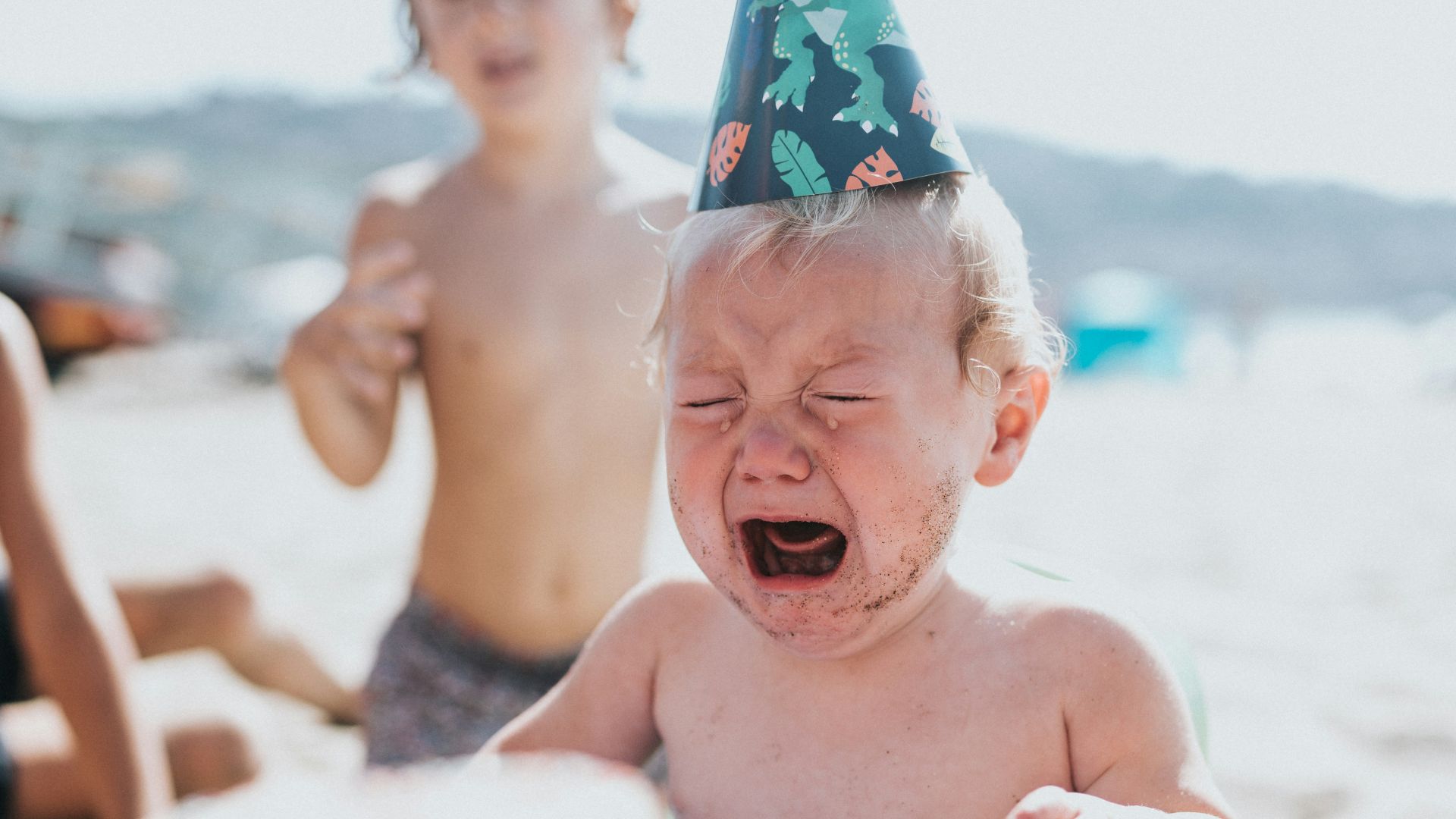 topless boy in blue and white floral shorts sitting on white and blue inflatable pool during