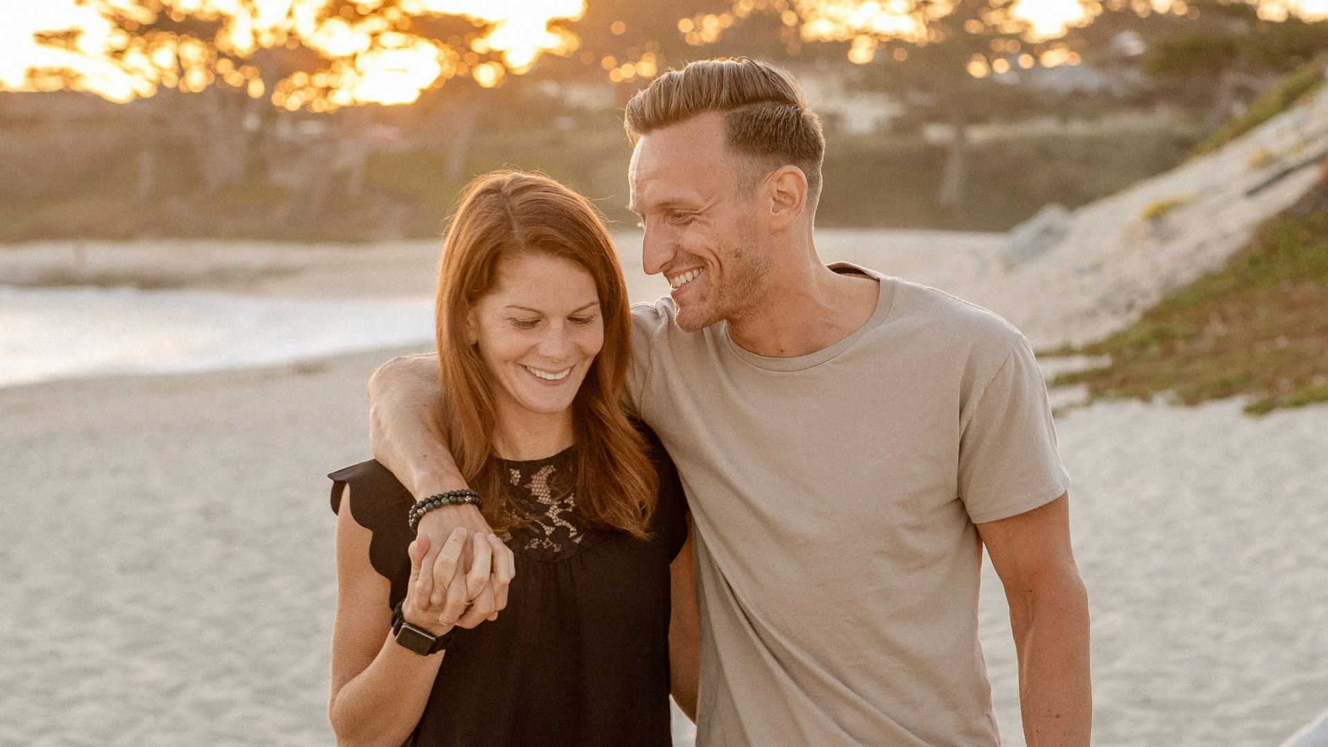 man and woman standing on beach during daytime
