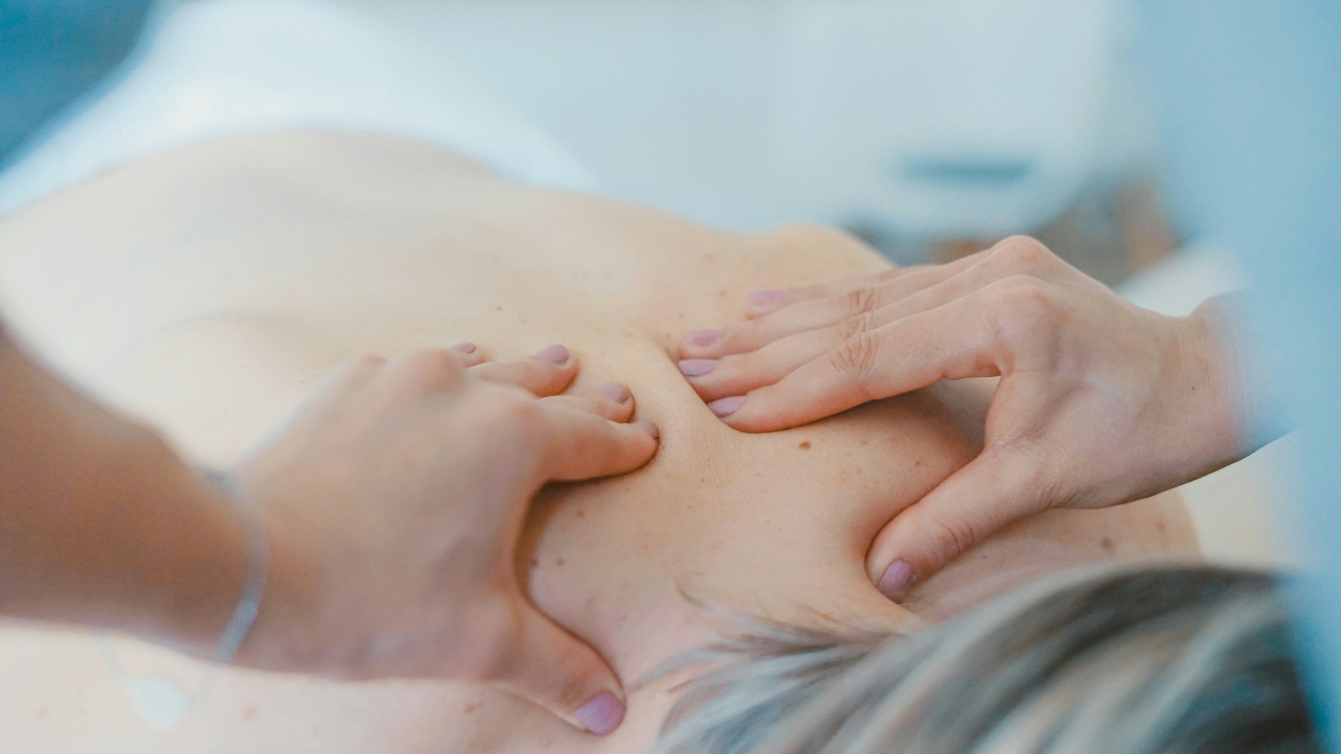 person massaging the back of a woman