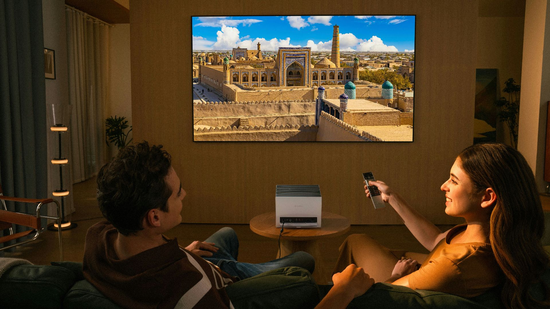 Couple watching a movie on a large screen television.