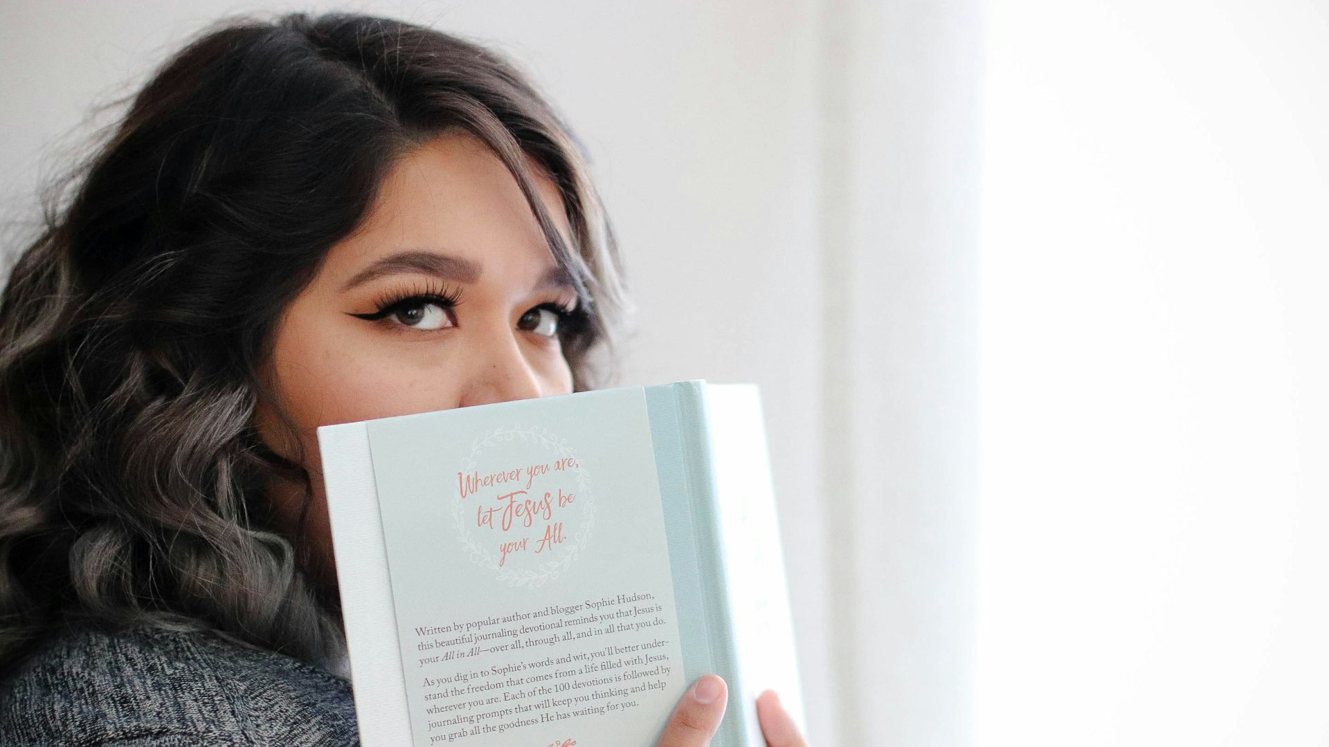 woman covering her face with book