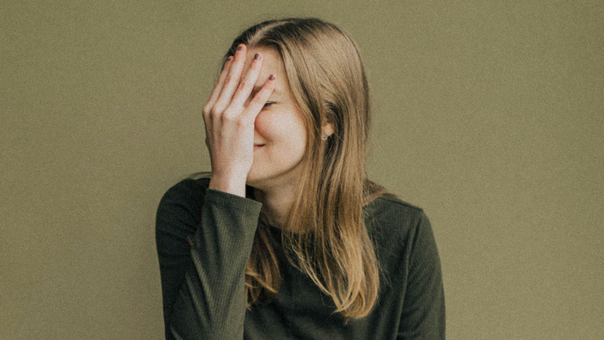 woman in black long sleeve shirt and blue denim jeans sitting on brown wooden chair