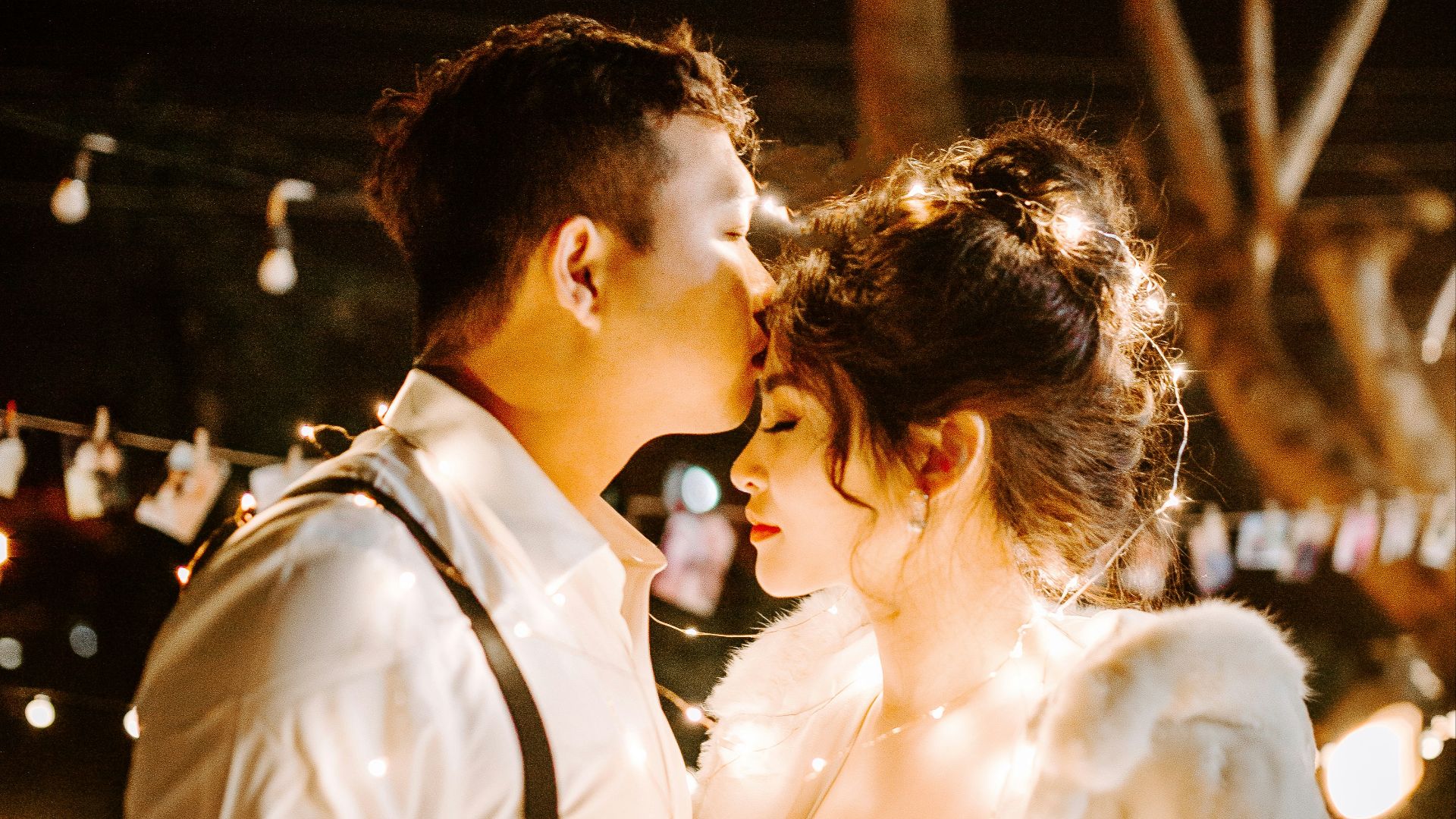 man kissing woman's forehead