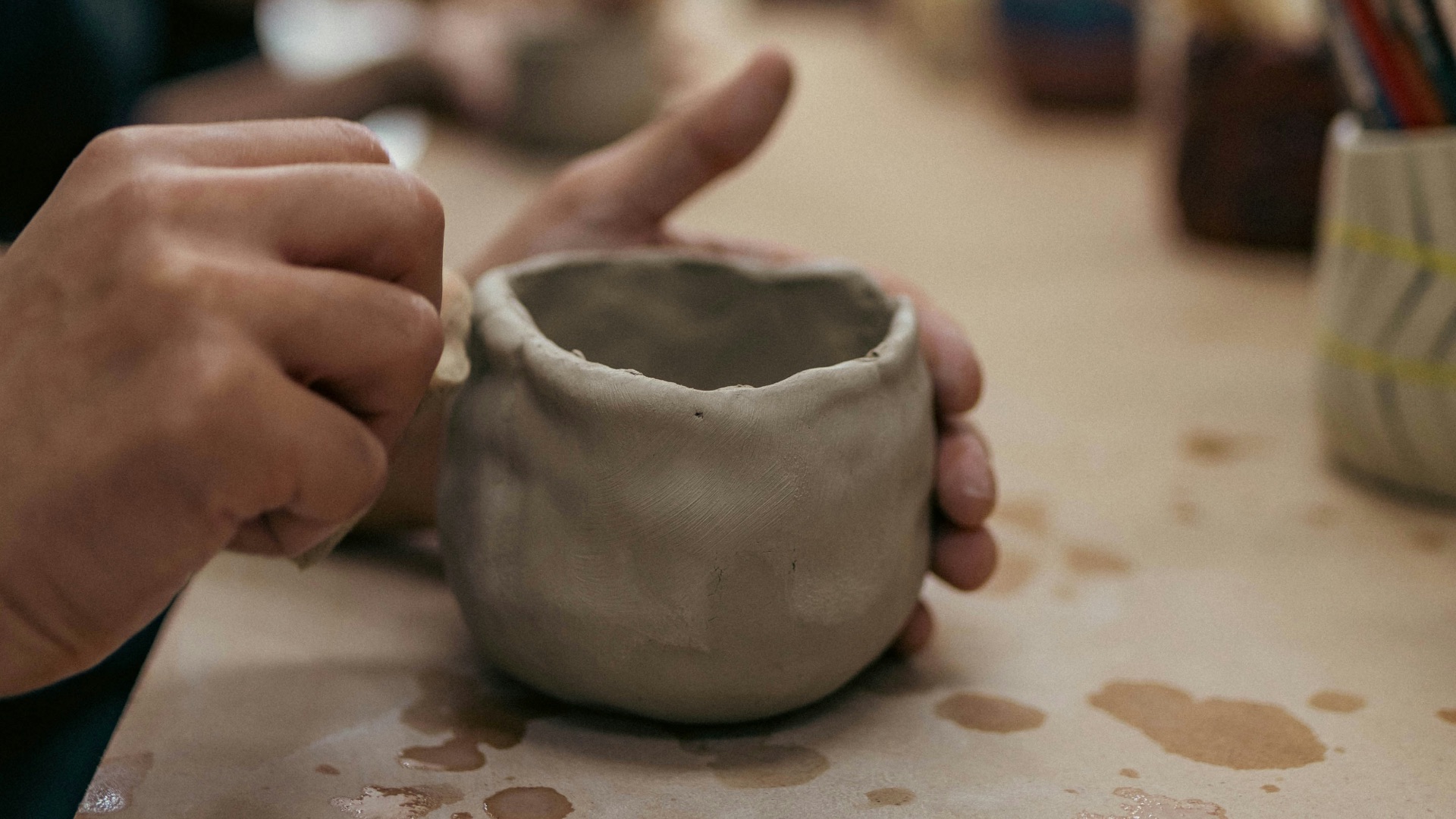 A person sitting at a table with a cup in front of them