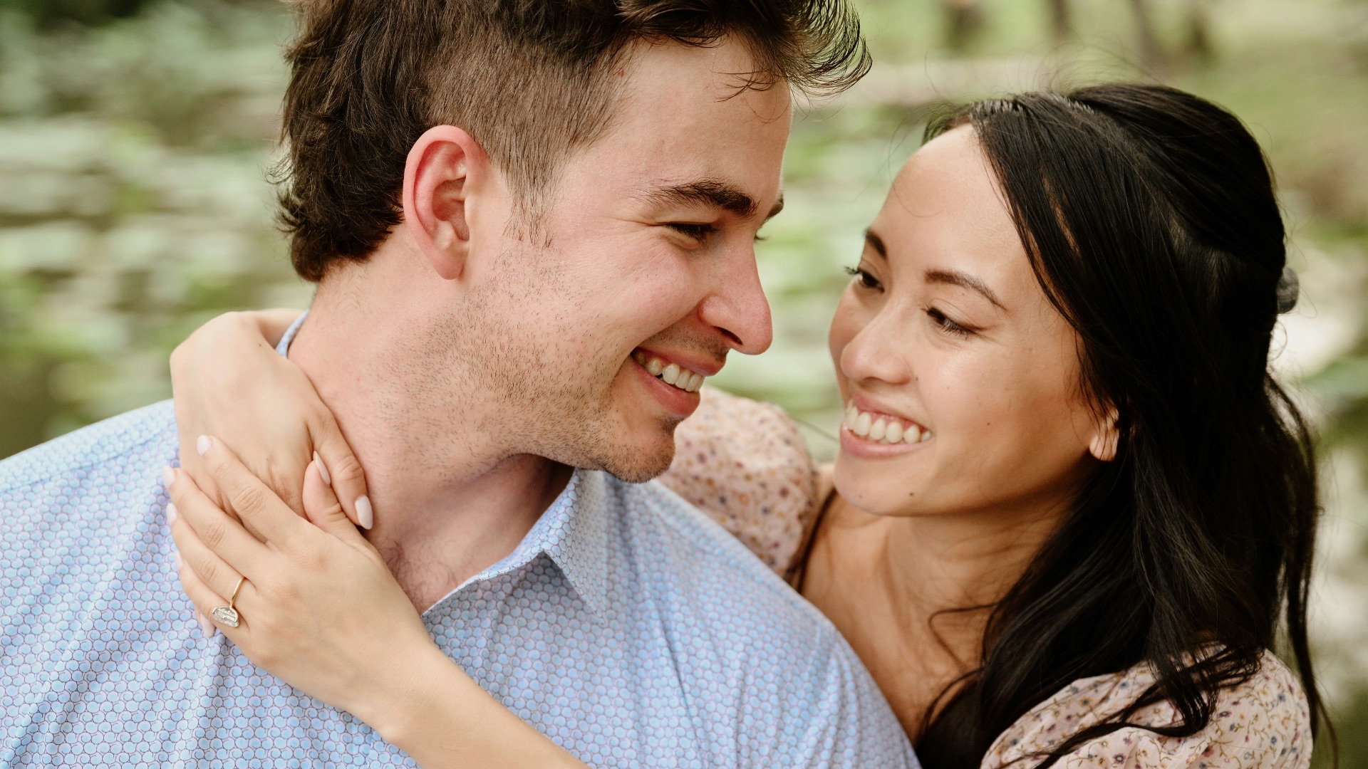 A happy couple smiling at each other outdoors