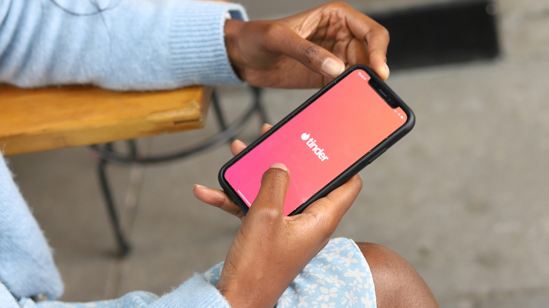 a woman sitting on a bench holding a cell phone