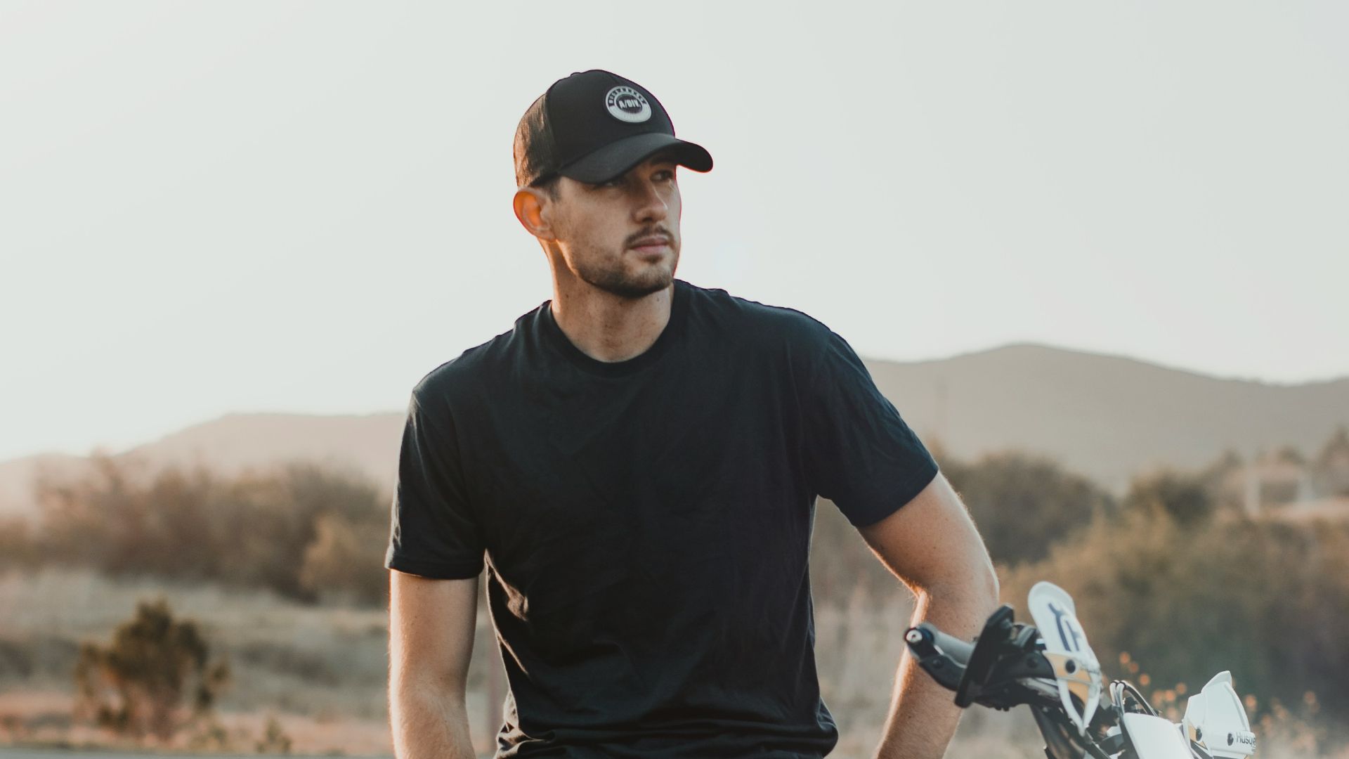 man in black crew neck t-shirt and gray denim jeans sitting on blue and white