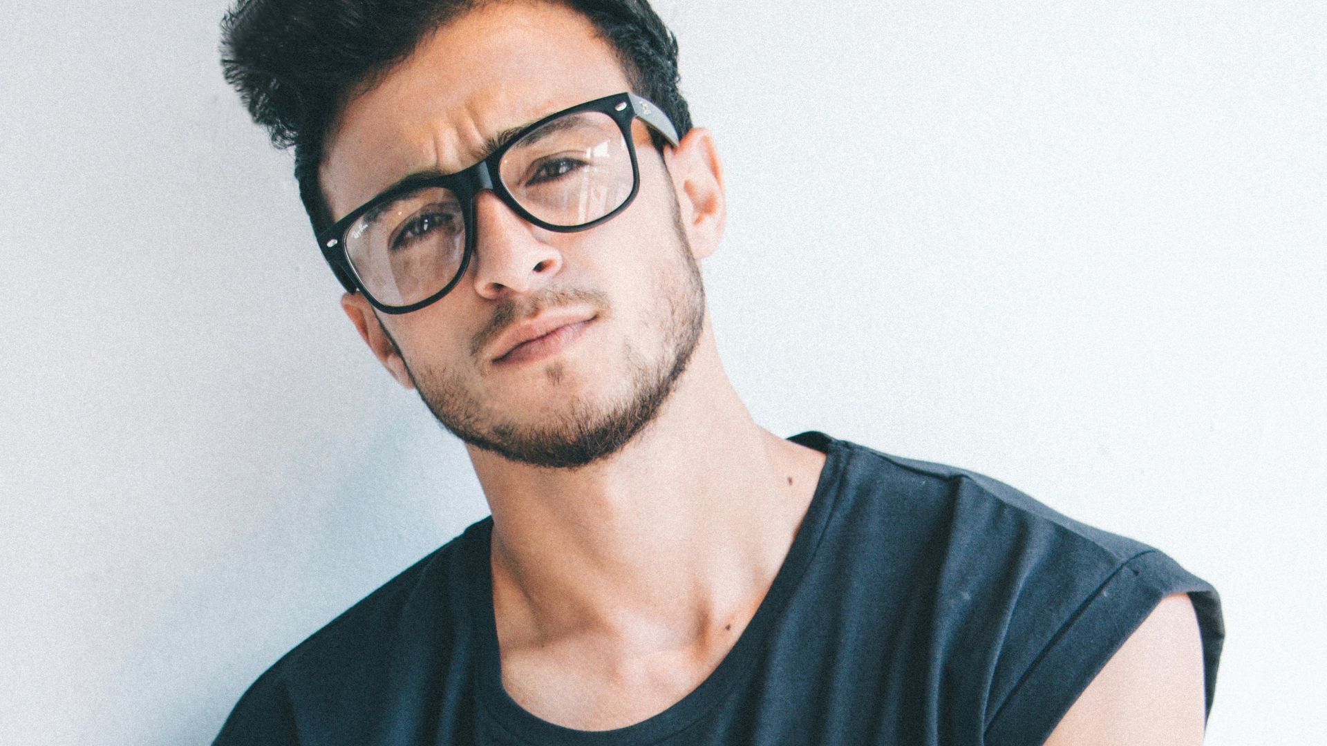 man wearing eyeglasses and sleeveless top