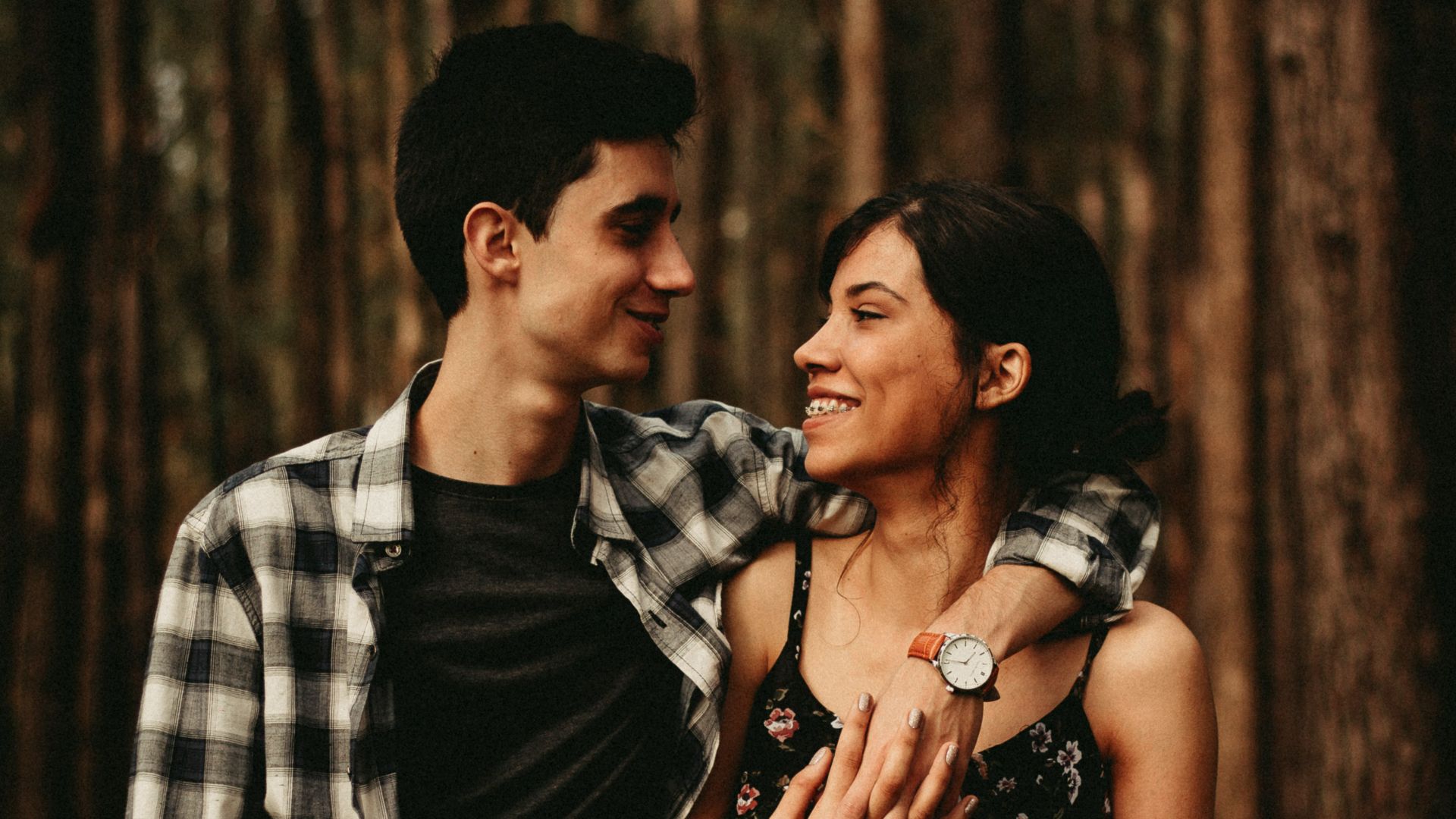 man wrapping arm on woman facing each other