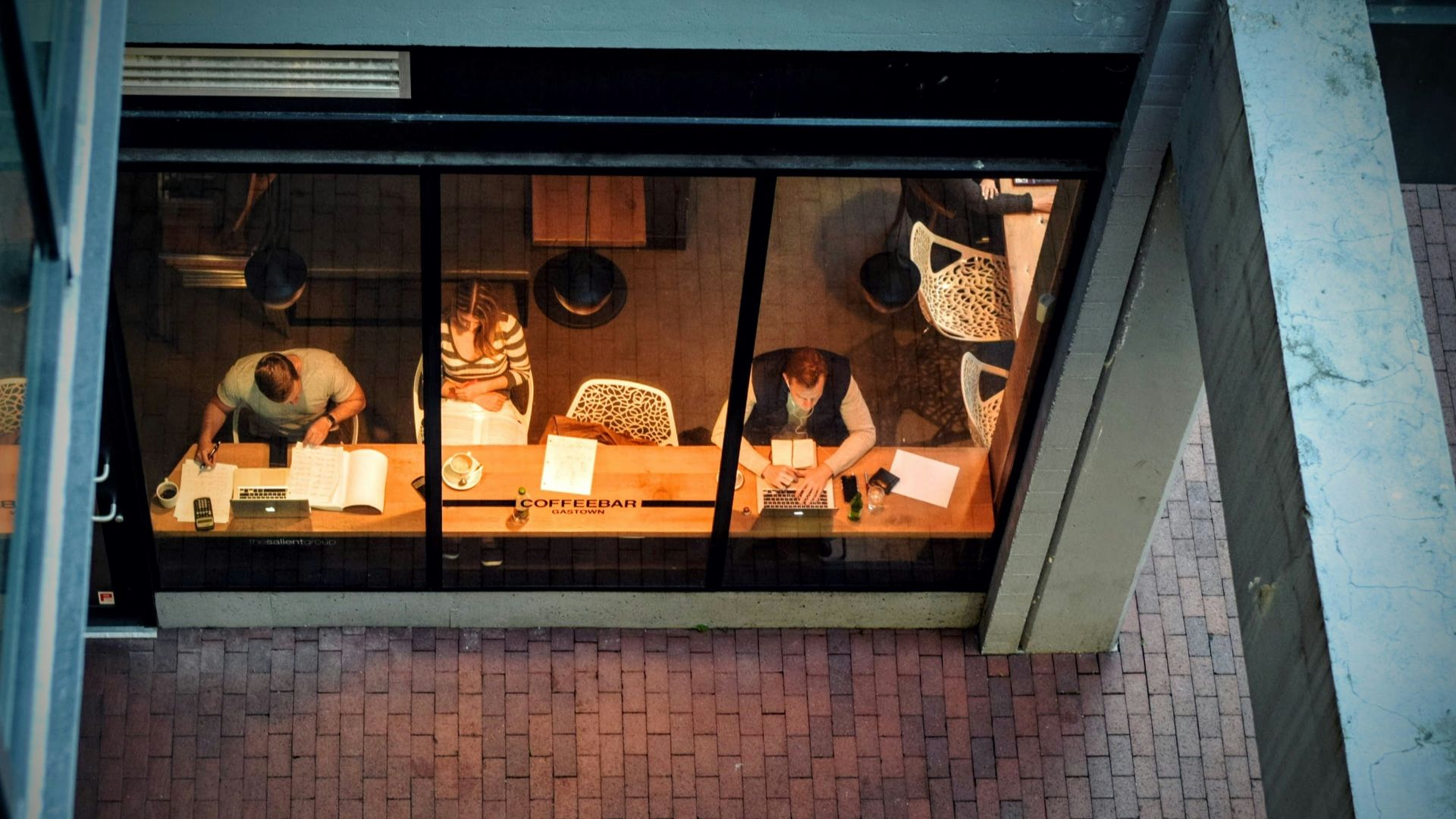 three persons sitting on chair beside table
