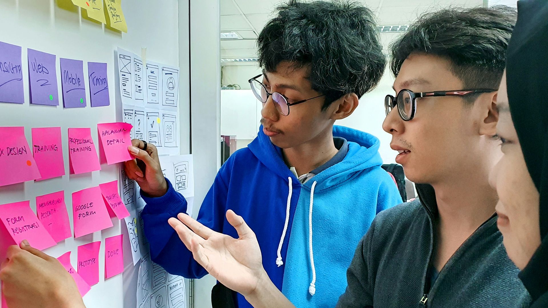 man in black framed eyeglasses holding purple and white box