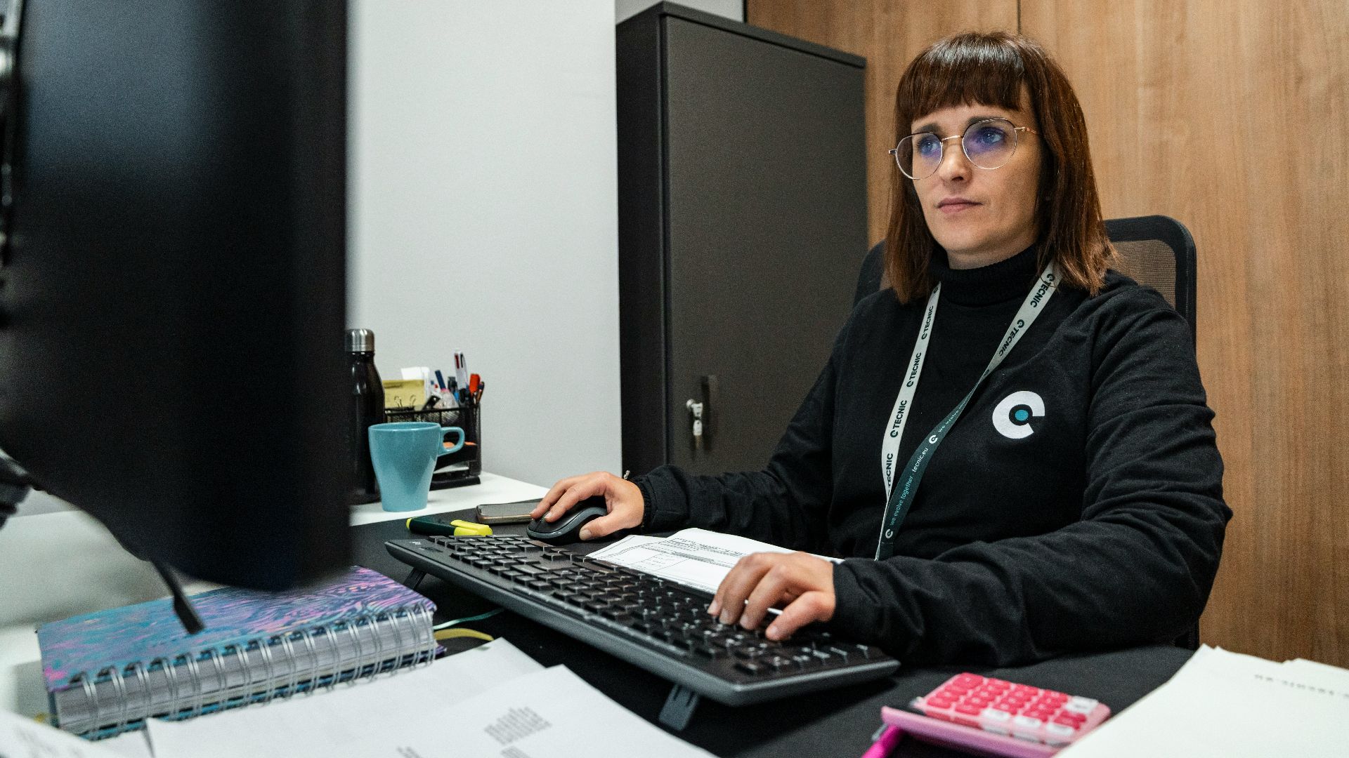 A woman is working at her office desk.