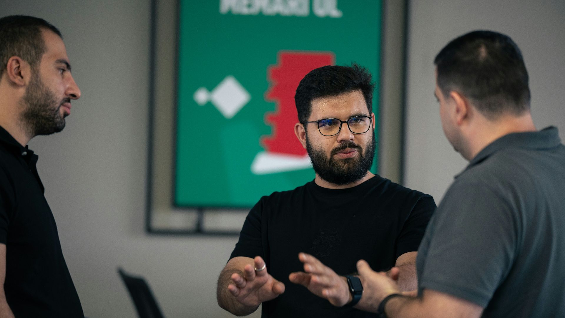 A group of men standing around each other in a room