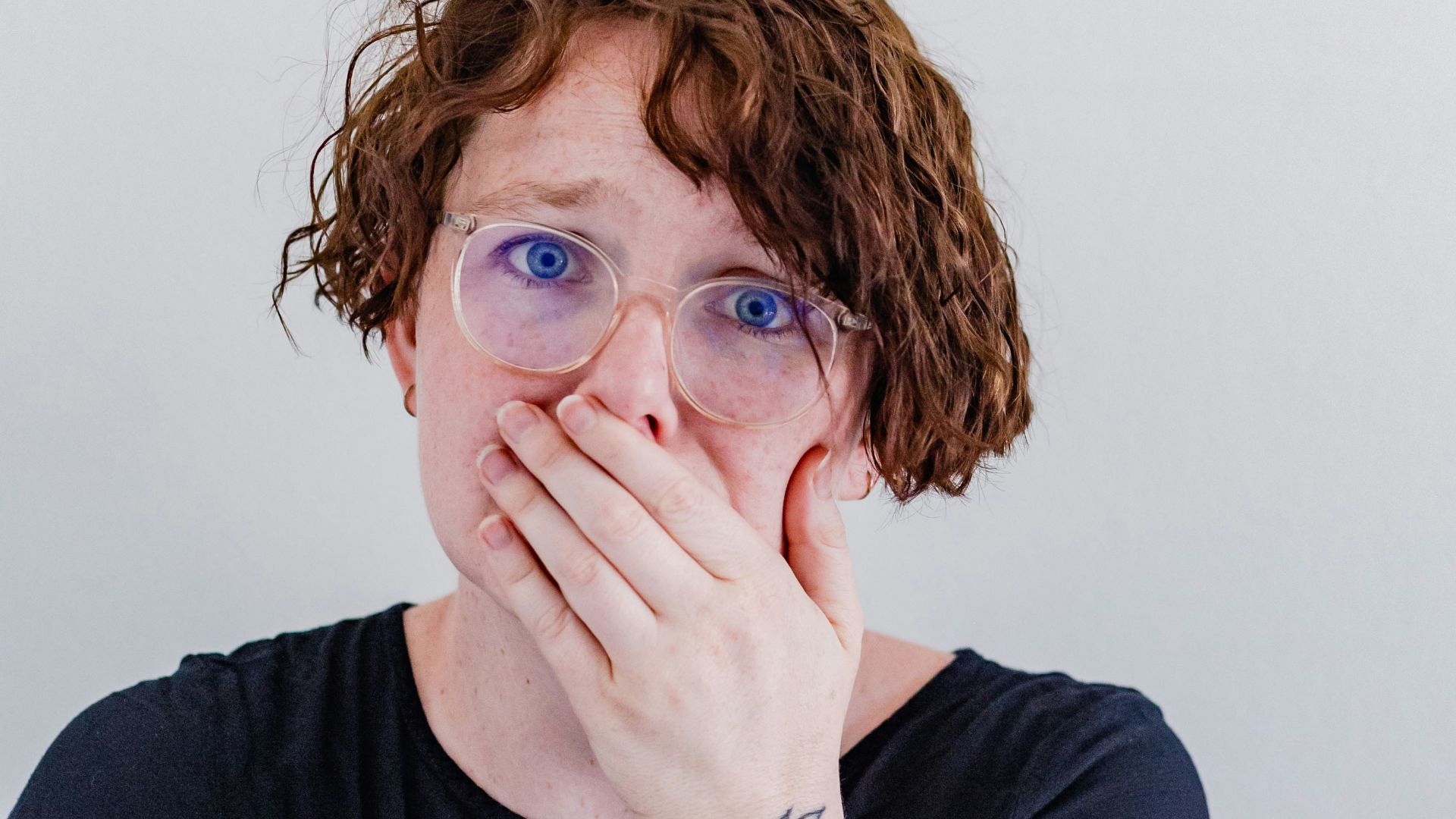 a woman covers her mouth with her hands