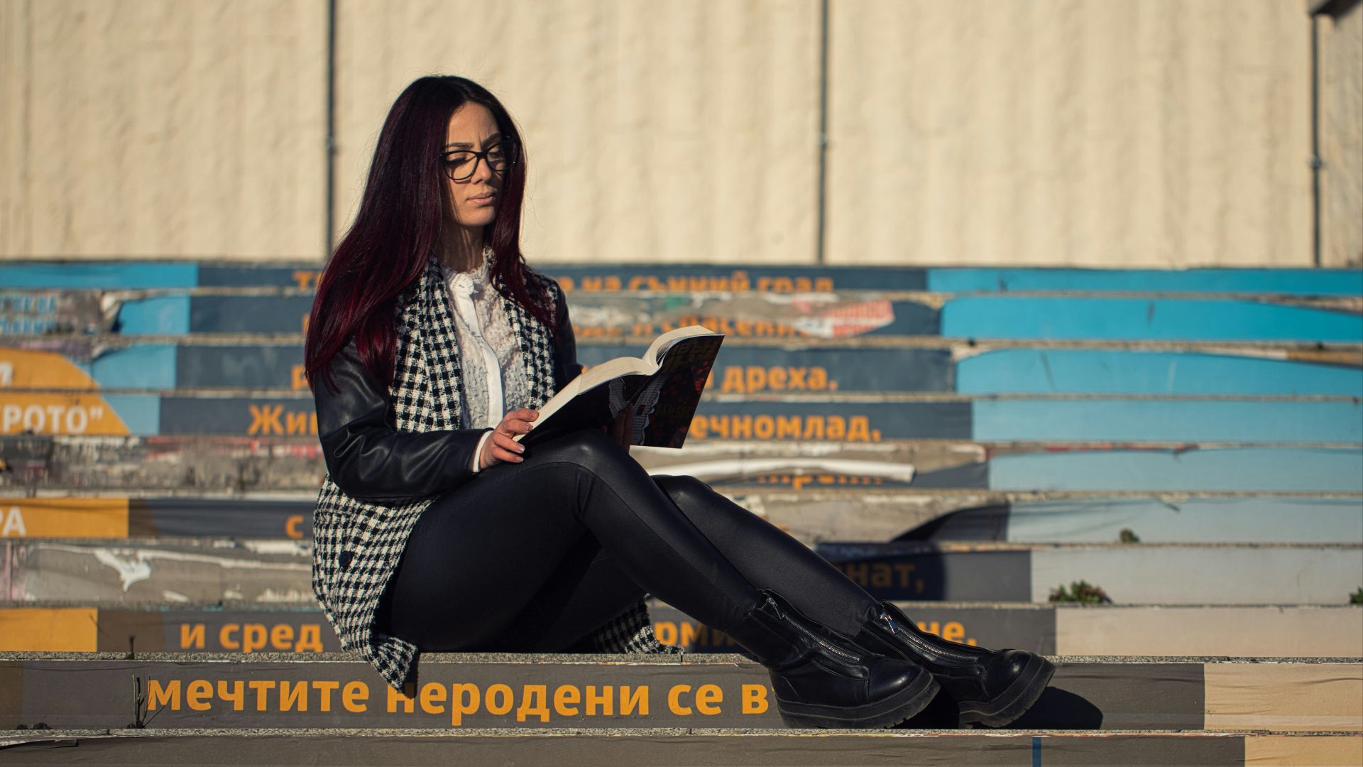a woman sitting on the ground reading a book