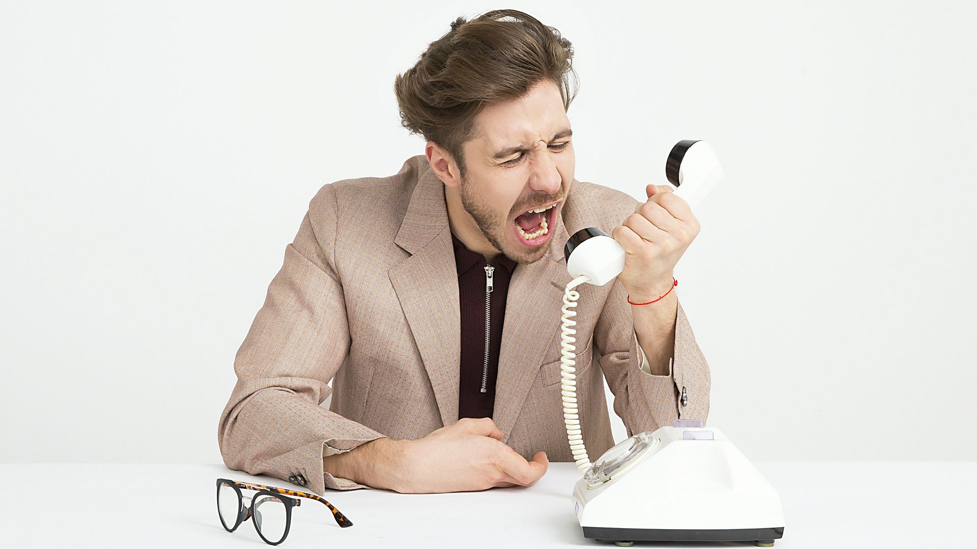 man holding telephone screaming