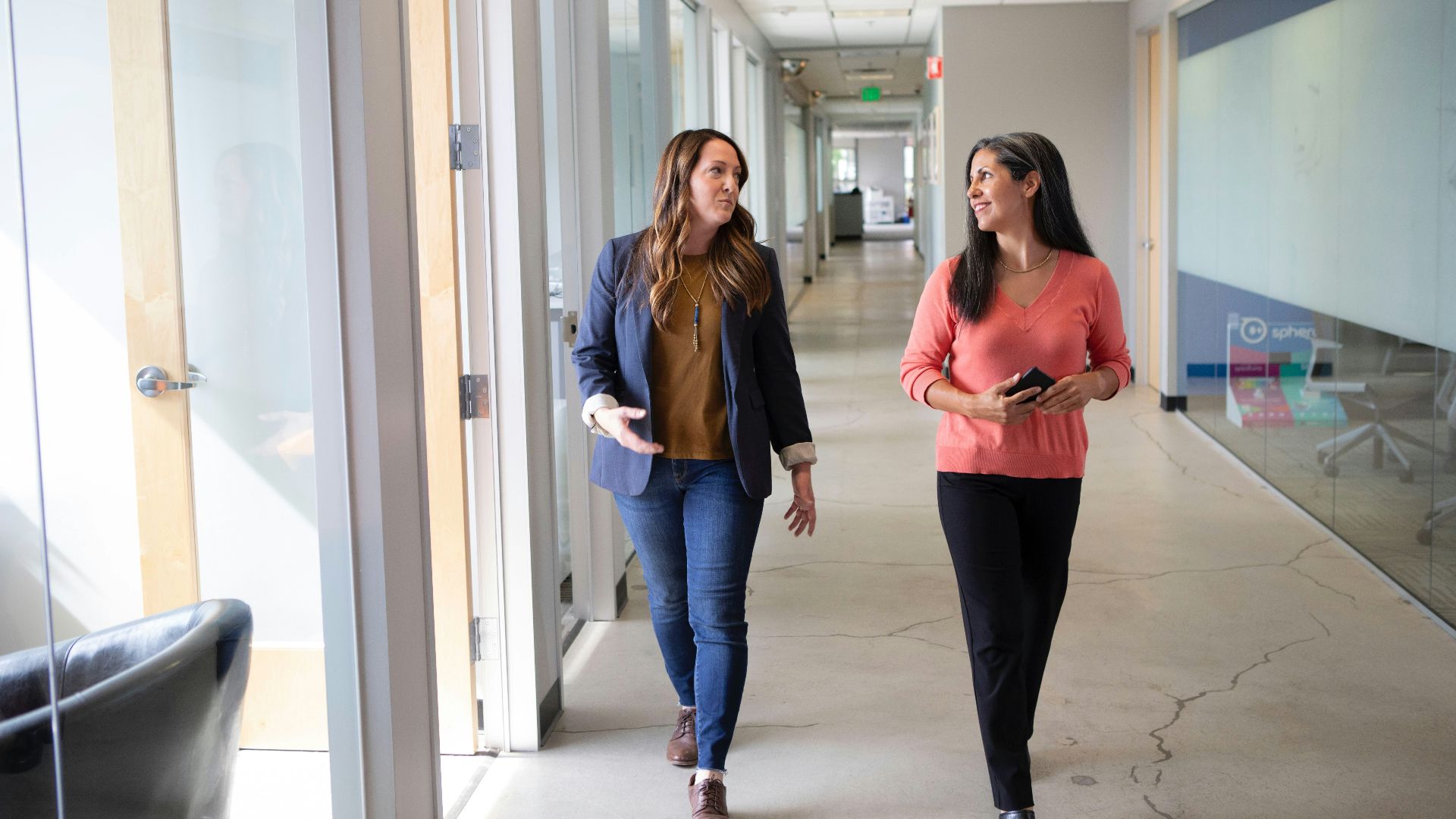 2 women standing near white wall
