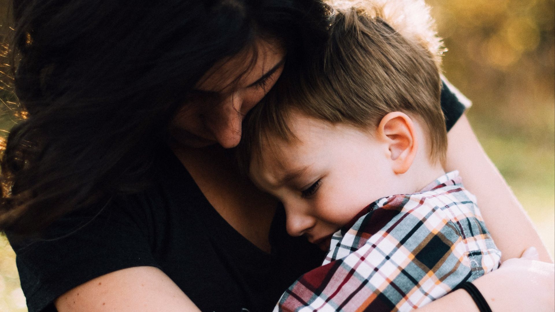 woman hugging boy on her lap