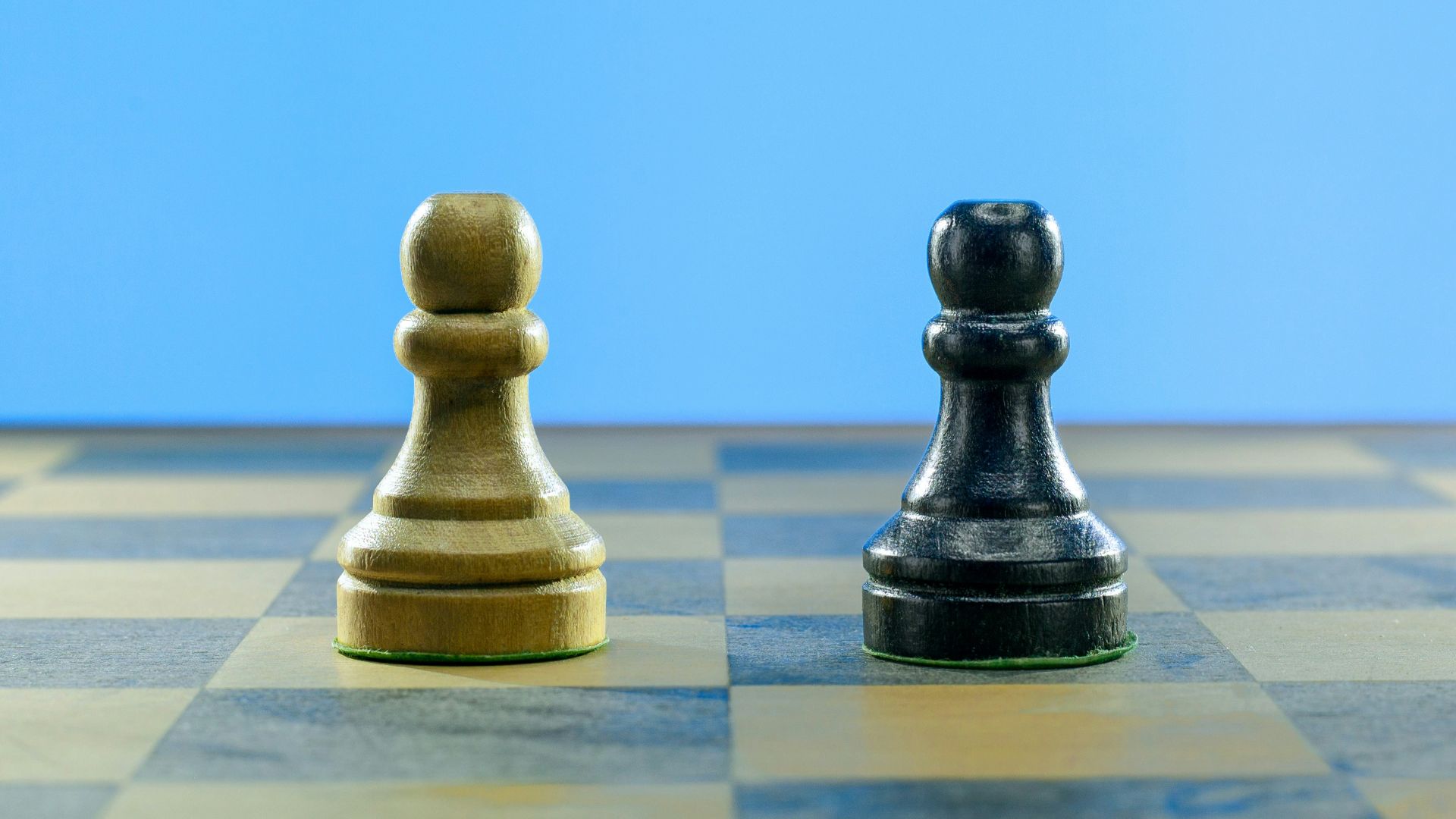 a black and a white chess piece on a checkered board