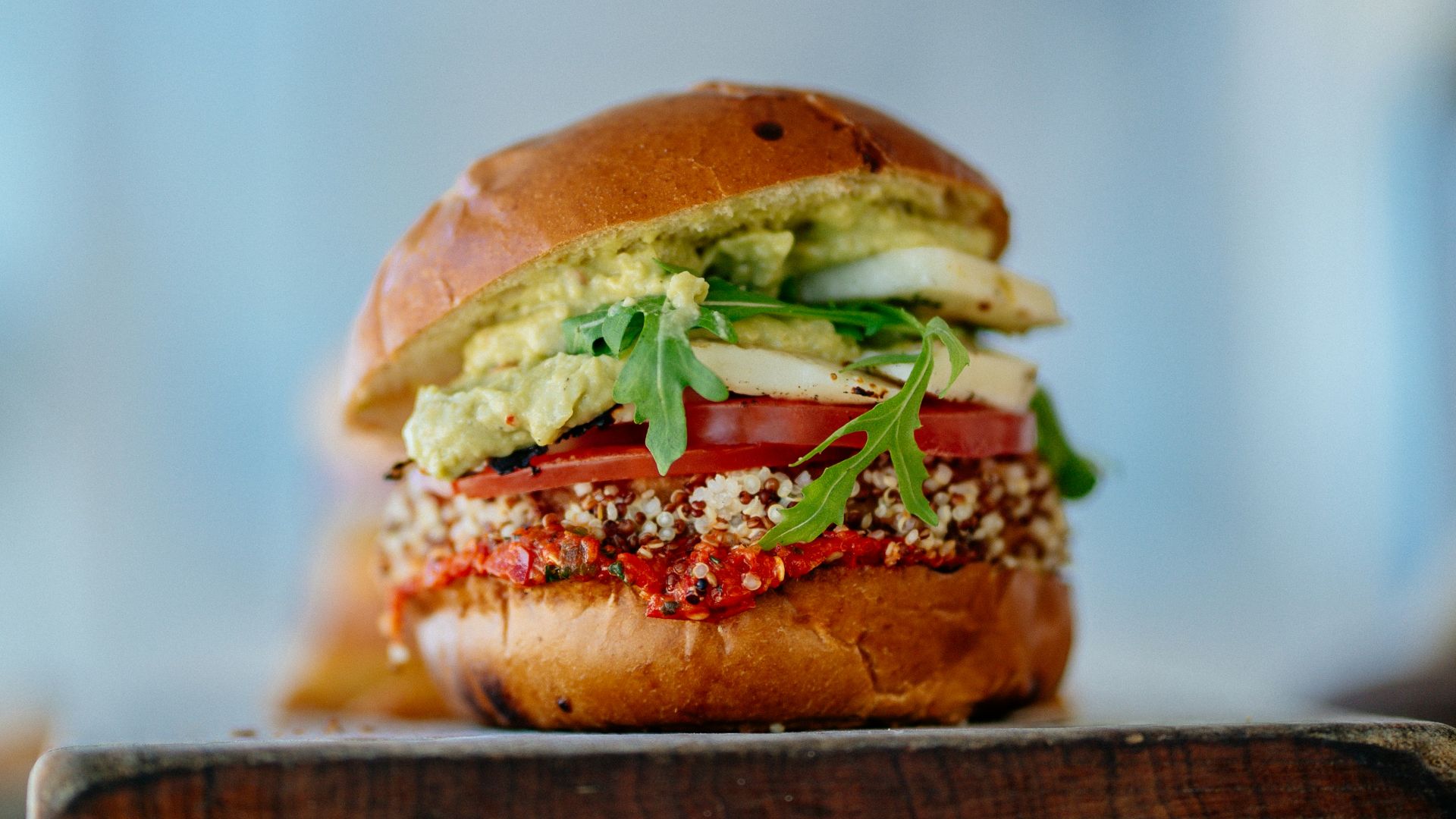 selective focus photography of hamburger with sliced tomatoes and vegetables