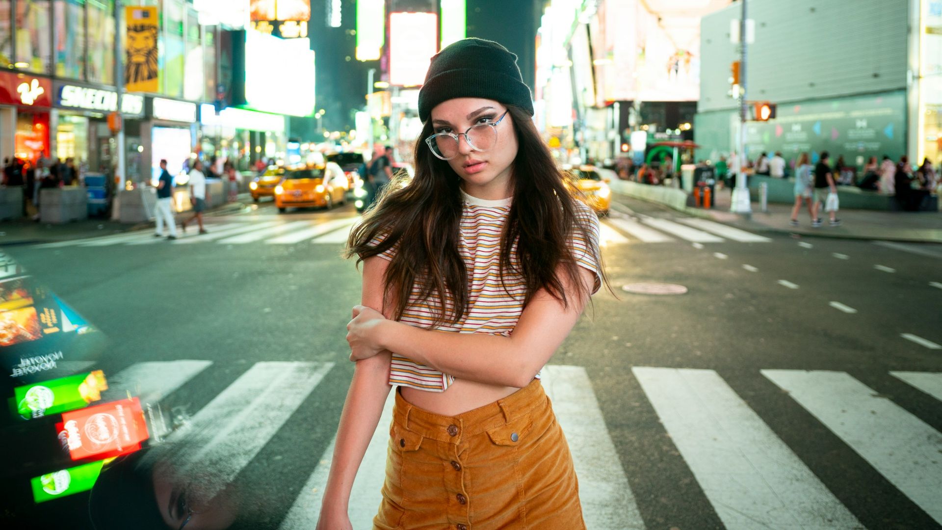 woman wearing black beanie standing across highway