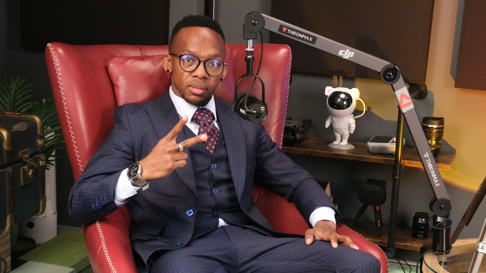 a man in a suit sitting in a red chair