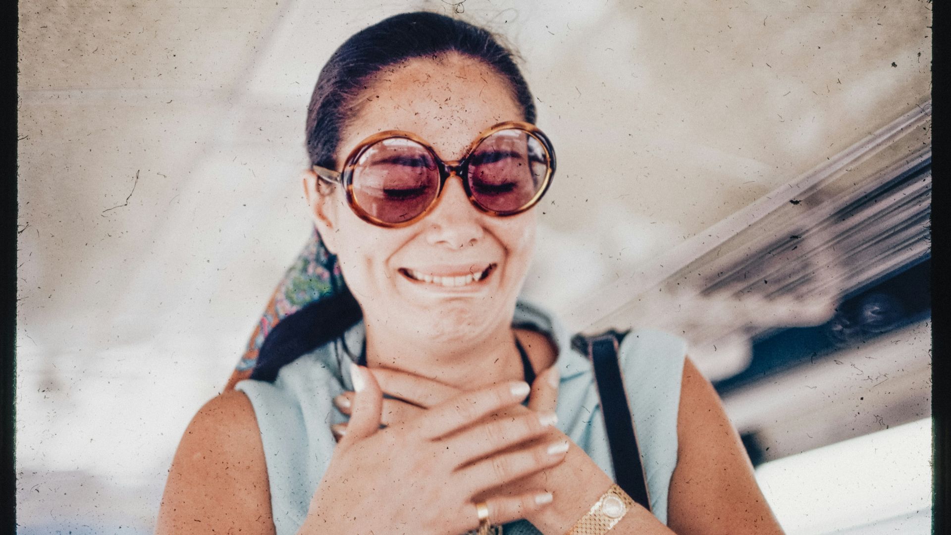 A woman wearing sunglasses is smiling for the camera