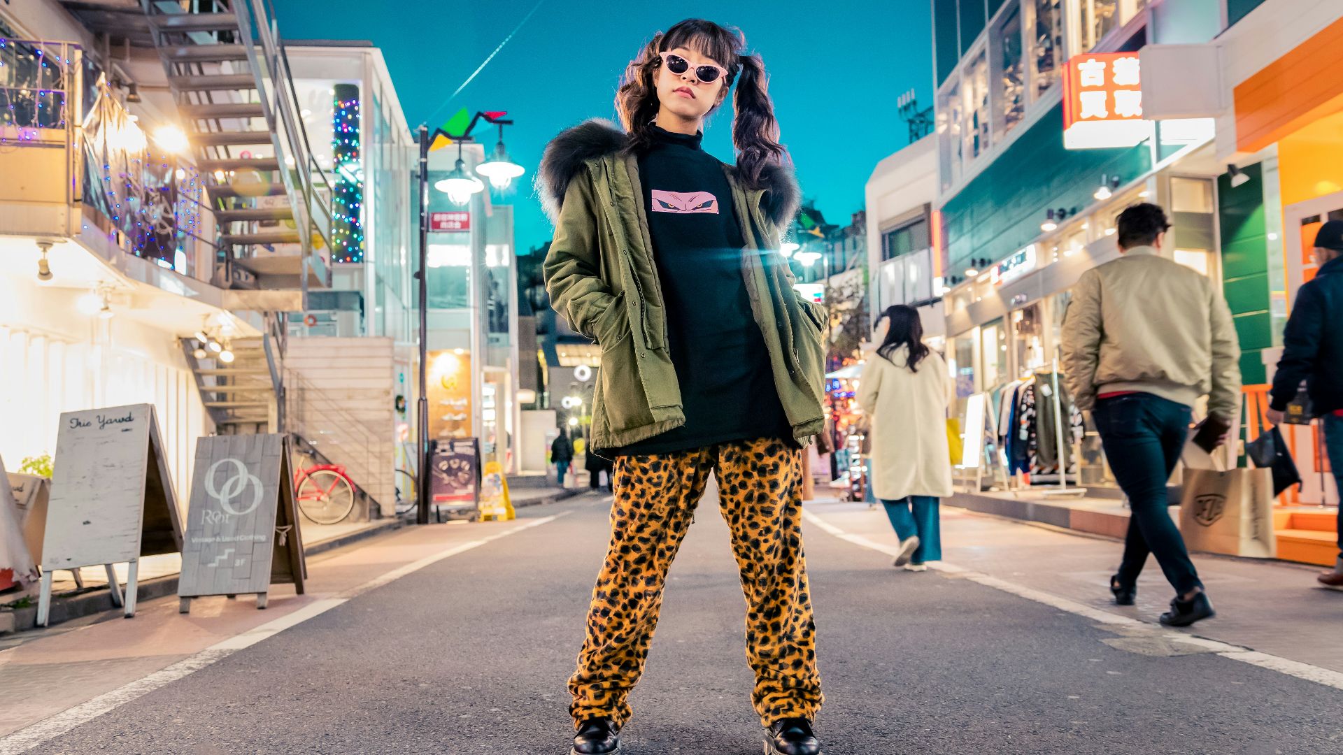 woman in green jacket stands and pose on street