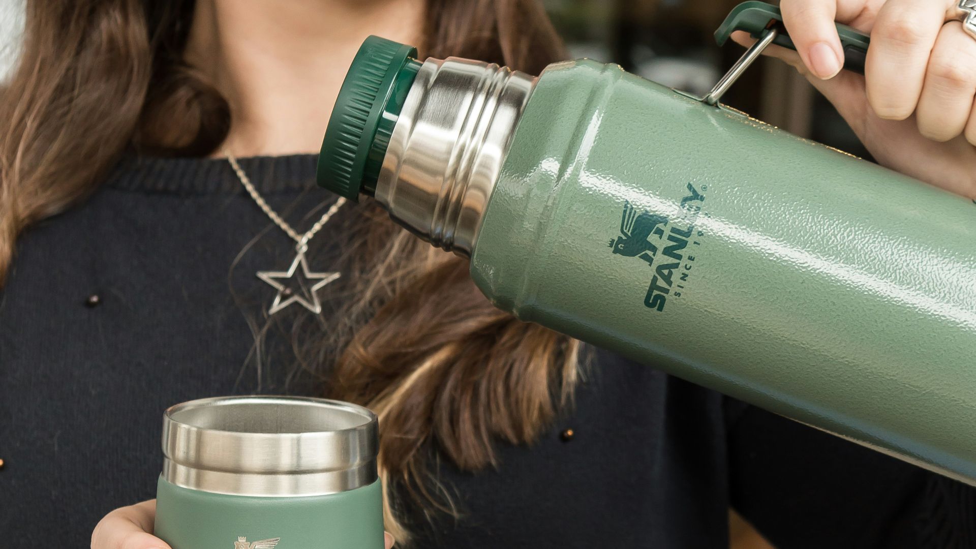 a woman is holding a cup and a water bottle