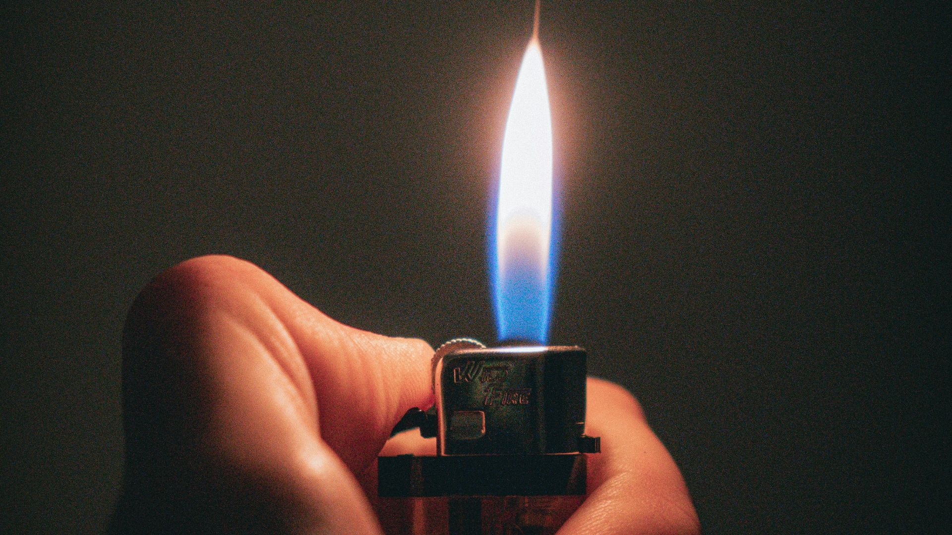 a person holding a lighter in their hand