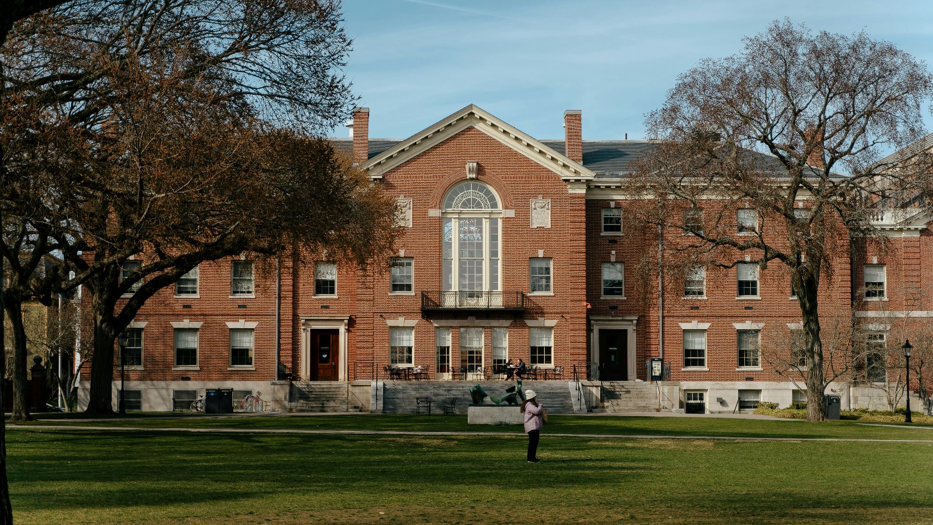 a person standing in front of a large brick building
